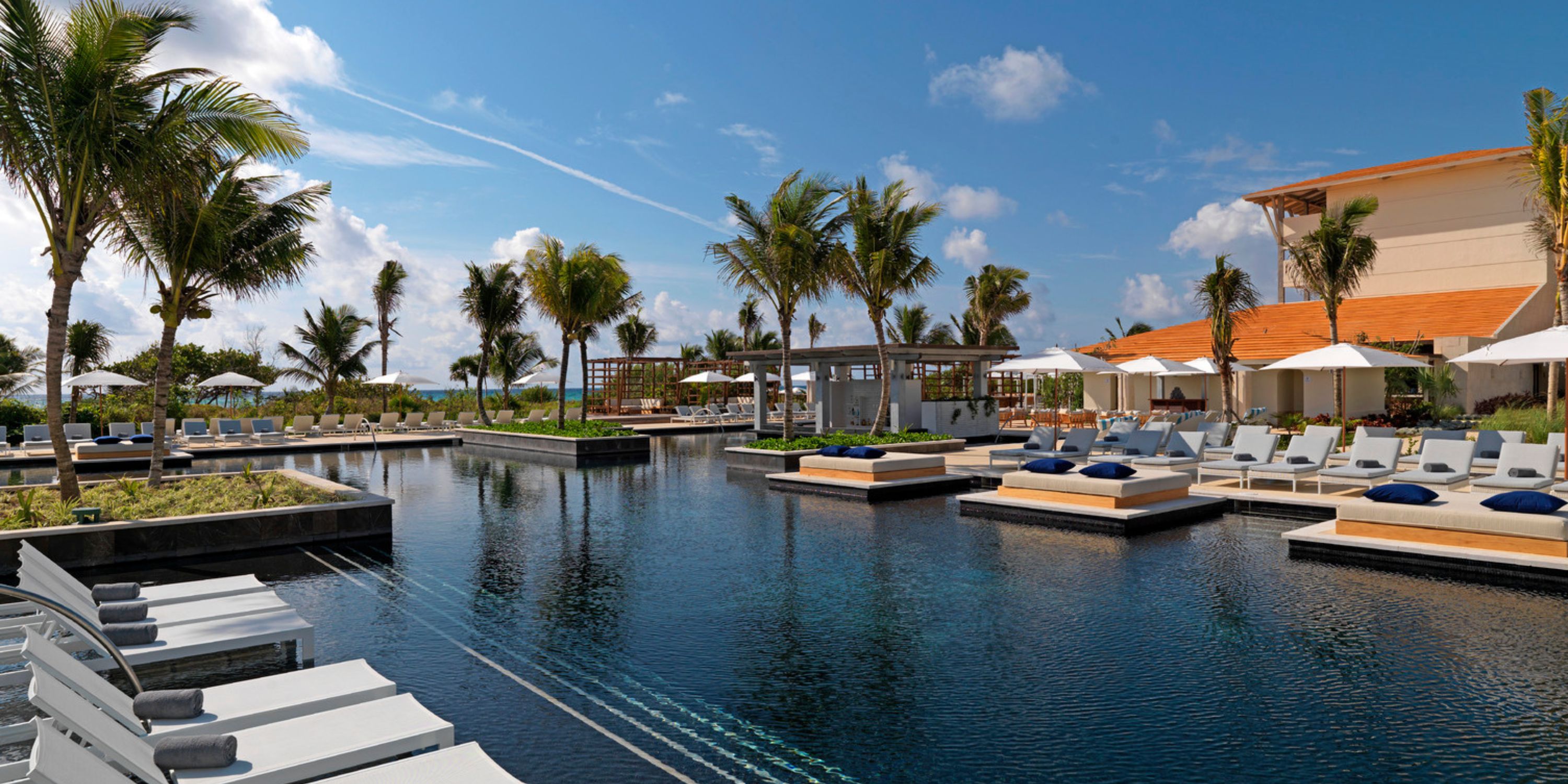 Modern outdoor pool at UNICO 20&deg;87&deg; Riviera Maya, perfect for destination weddings, with lounge chairs.