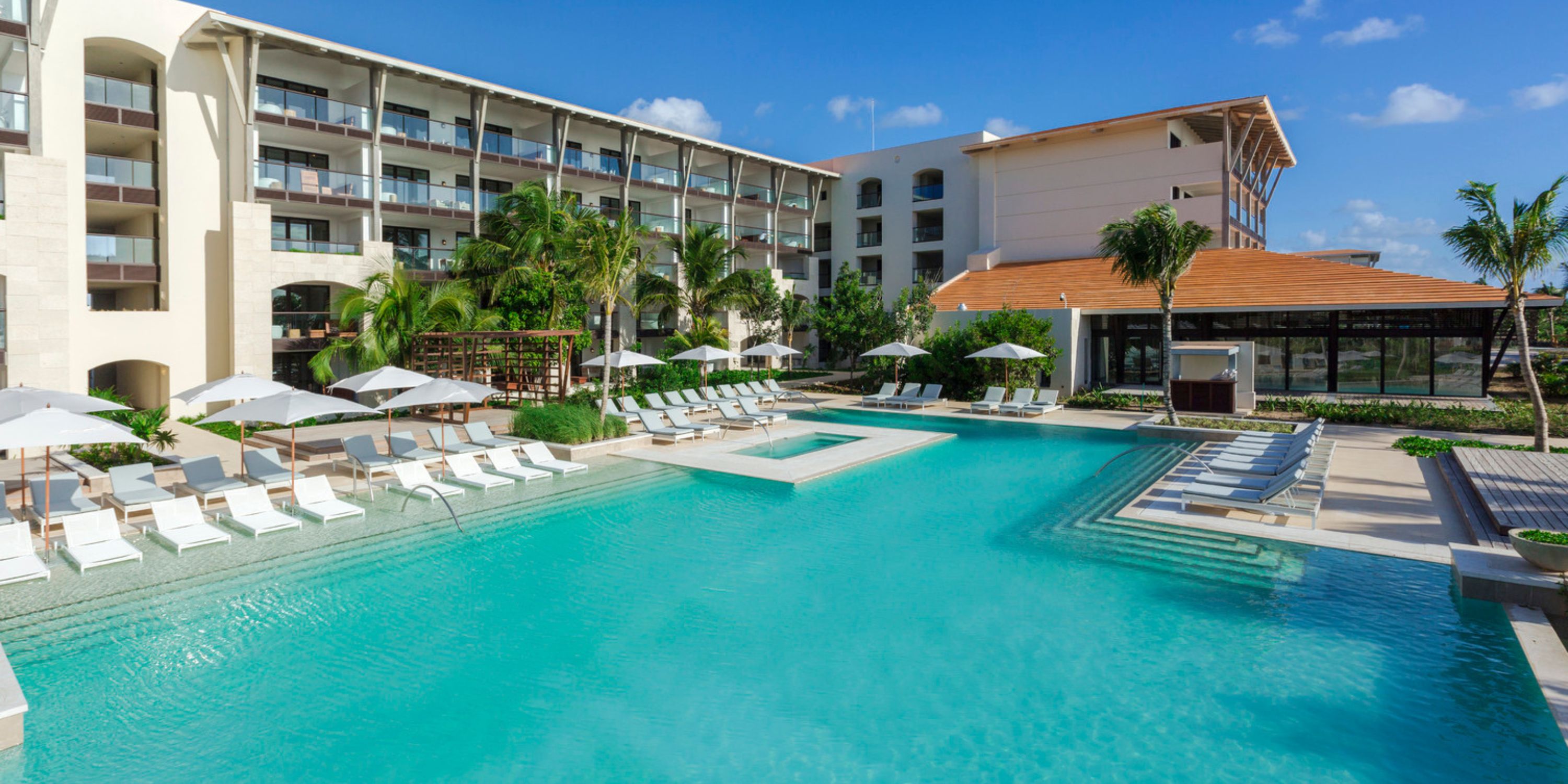 UNICO 20&deg;87&deg; Riviera Maya outdoor pool, perfect for destination weddings, with lounge chairs and umbrellas.