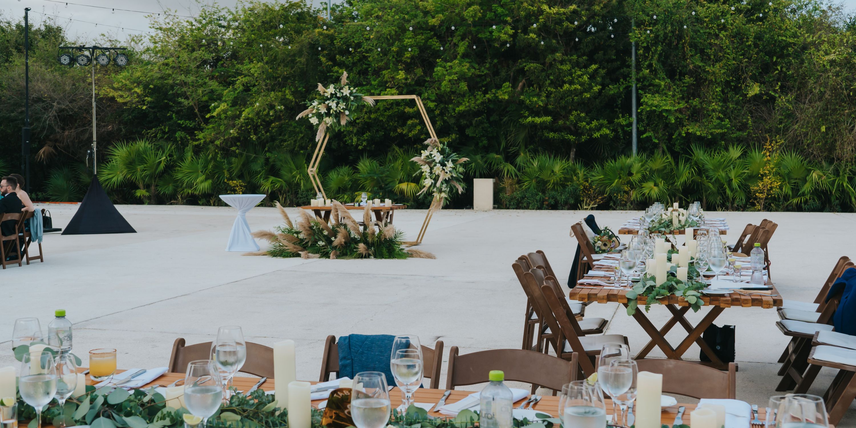 Destination wedding setup at UNICO 20&deg;87&deg; Riviera Maya featuring decorated tables and a floral arch.