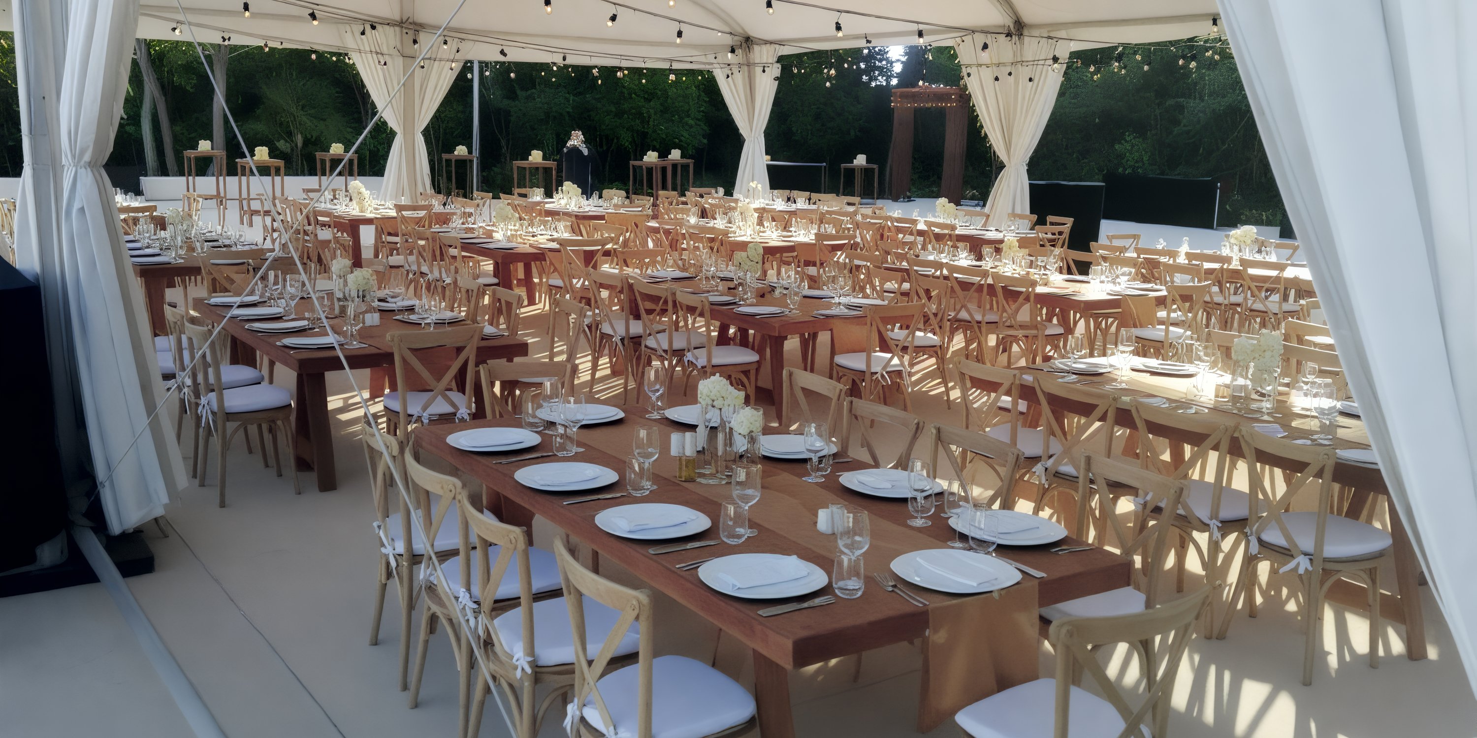 Wooden tables and chairs arranged under a white tent for a destination wedding at UNICO 20°87° Riviera Maya.