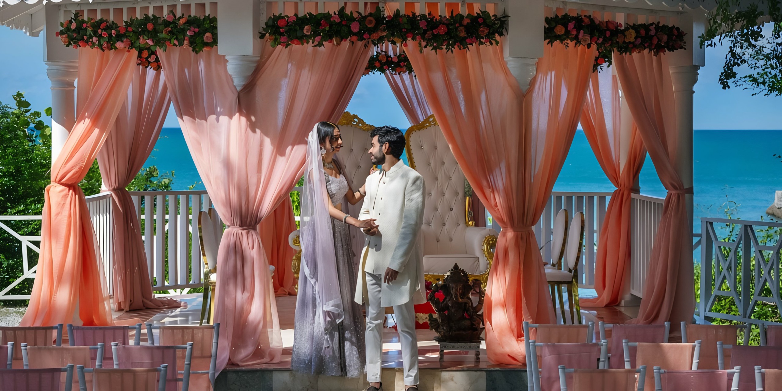 A couple exchanging vows at a Palladium Lady Hamilton beachfront wedding ceremony under a decorated gazebo.