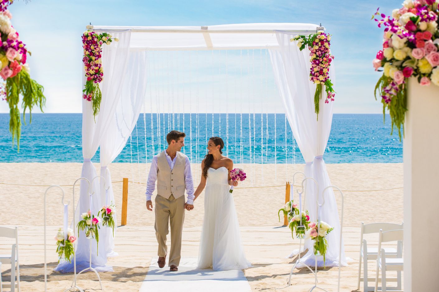 Newlywed bride and groom walk back up the aisle after an intimate elegance package wedding at Hyatt Ziva Los Cabos