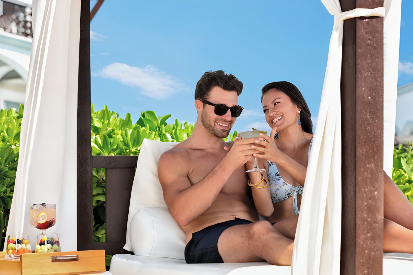 Couple enjoying a cocktail by the pool at an all-inclusive resort