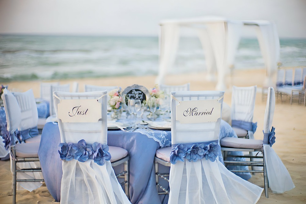 Elegant vintage ceremony with vintage lounge chairs, crystal chandelier and draping.
