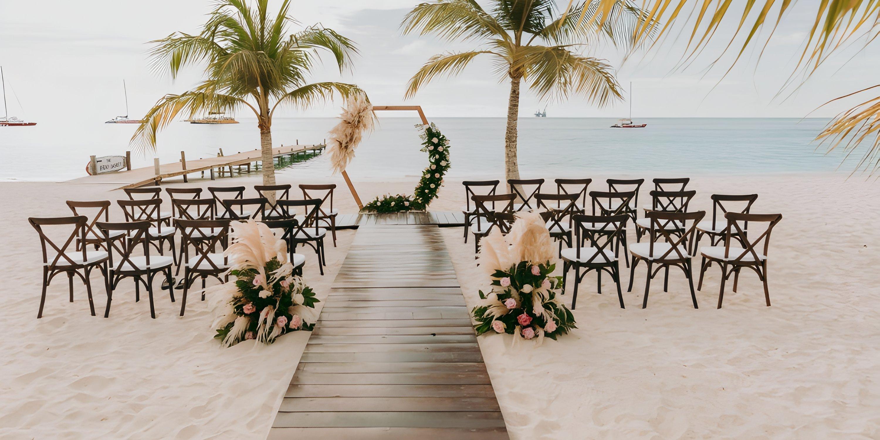 Destination wedding setup at Barcelo Aruba with chairs, flowers, and an arch overlooking the ocean.