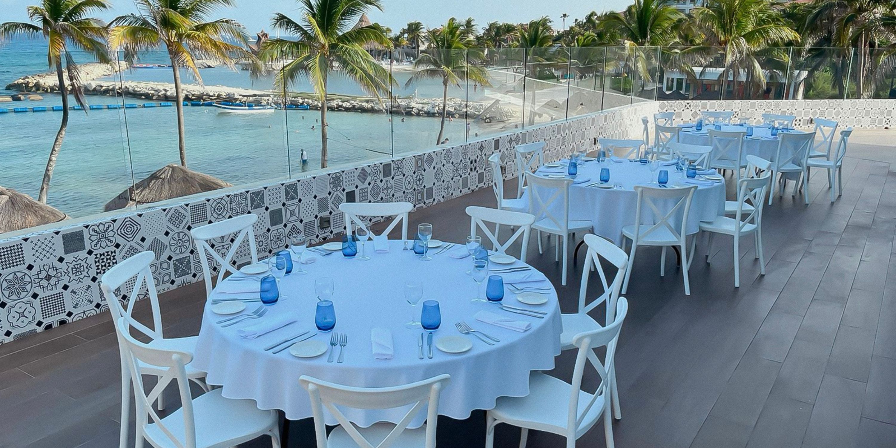 Outdoor dining setup at Catalonia Riviera Maya for a destination wedding, with ocean views and palms.