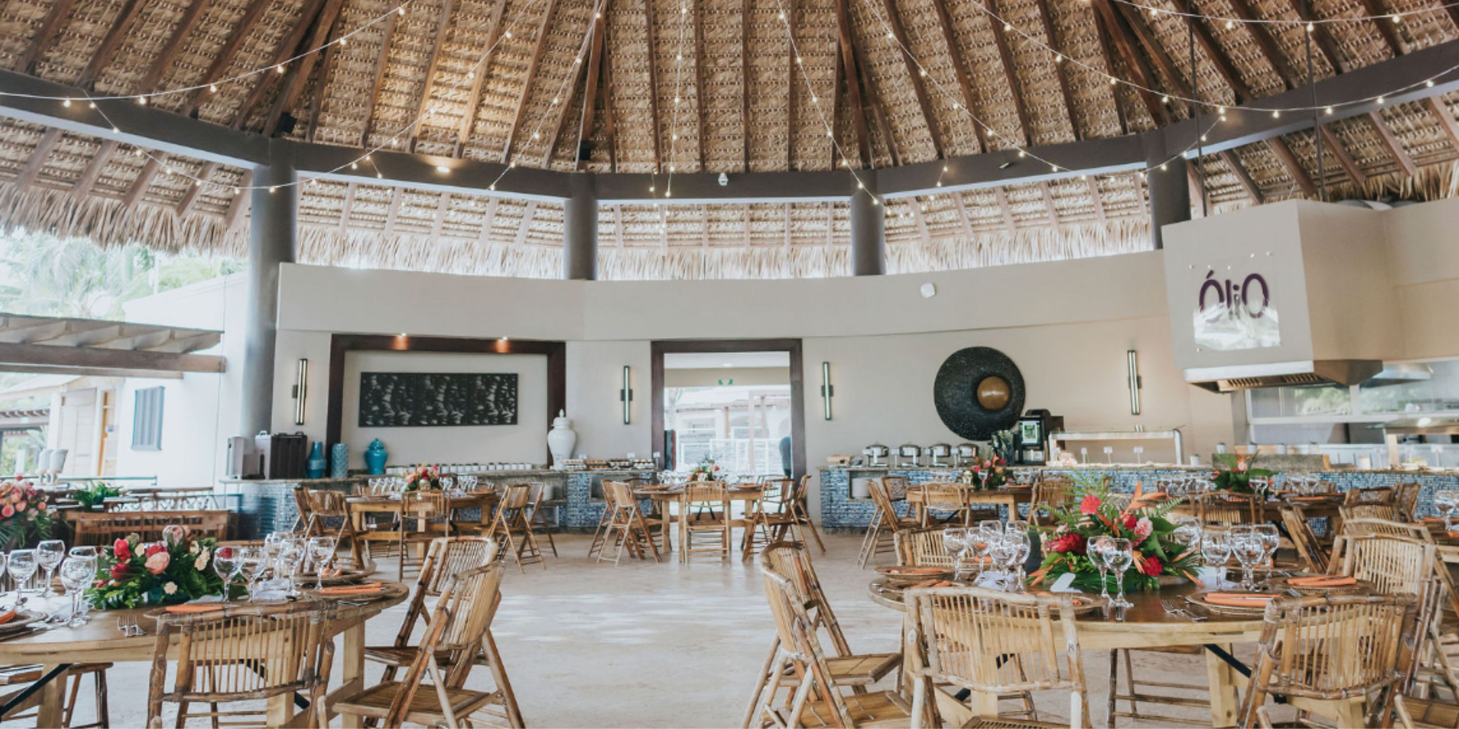 Open-air wedding dining at Dreams Royal Beach Punta Cana with bamboo chairs and floral centerpieces.