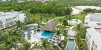 Aerial view of Dreams Royal Beach Punta Cana, a dreamy destination wedding spot with pools, palms, and huts.