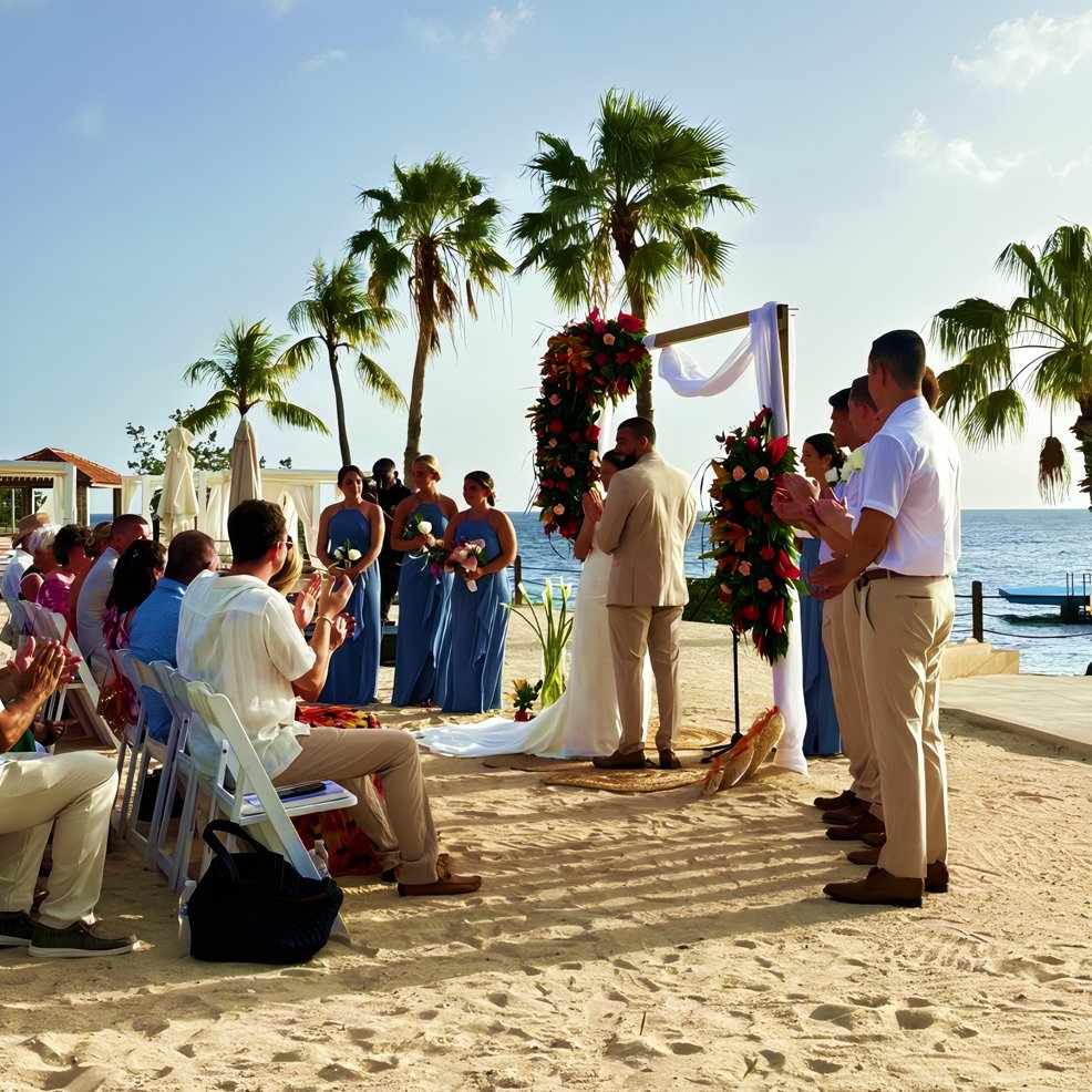 A destination wedding on the beach with guests seated, bridesmaids in blue, and the couple at the altar.