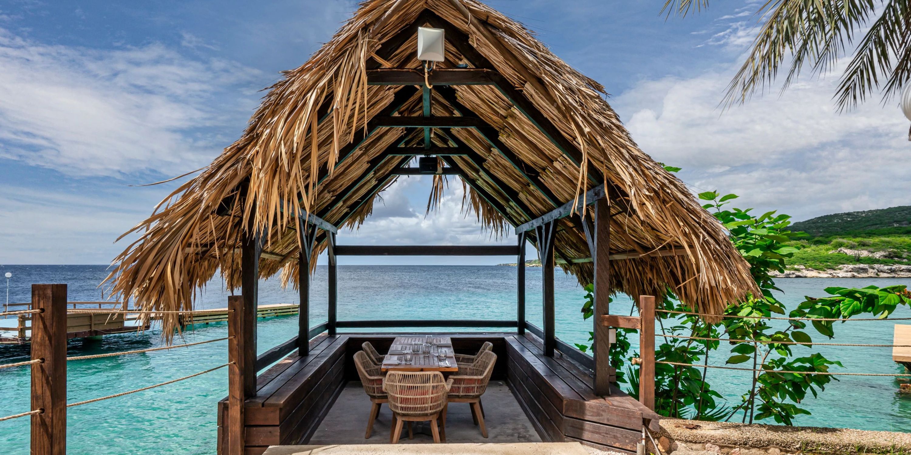 Dreams Curacao: Thatched pavilion with wooden table and chairs, ocean view&mdash;ideal for a destination wedding.