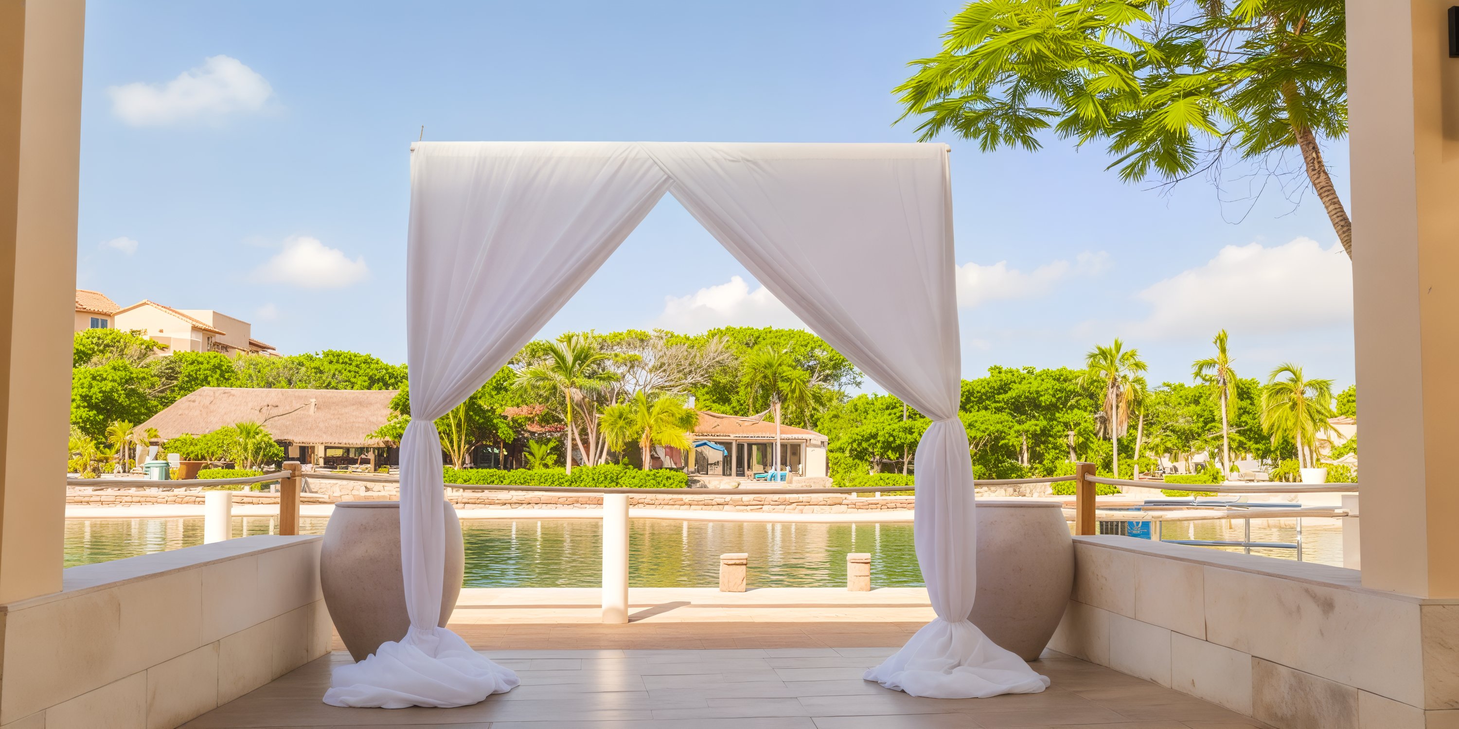 Dreams Aventuras Riviera Maya offers a stunning archway that overlooks a tropical waterfront and lush greenery, making it the perfect venue for a destination wedding.