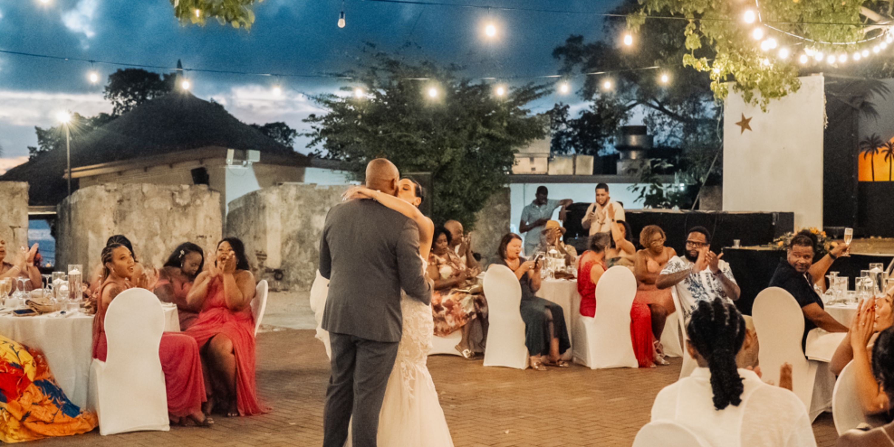 A couple dances at their destination wedding at Dreams Curacao as guests watch and snap photos.