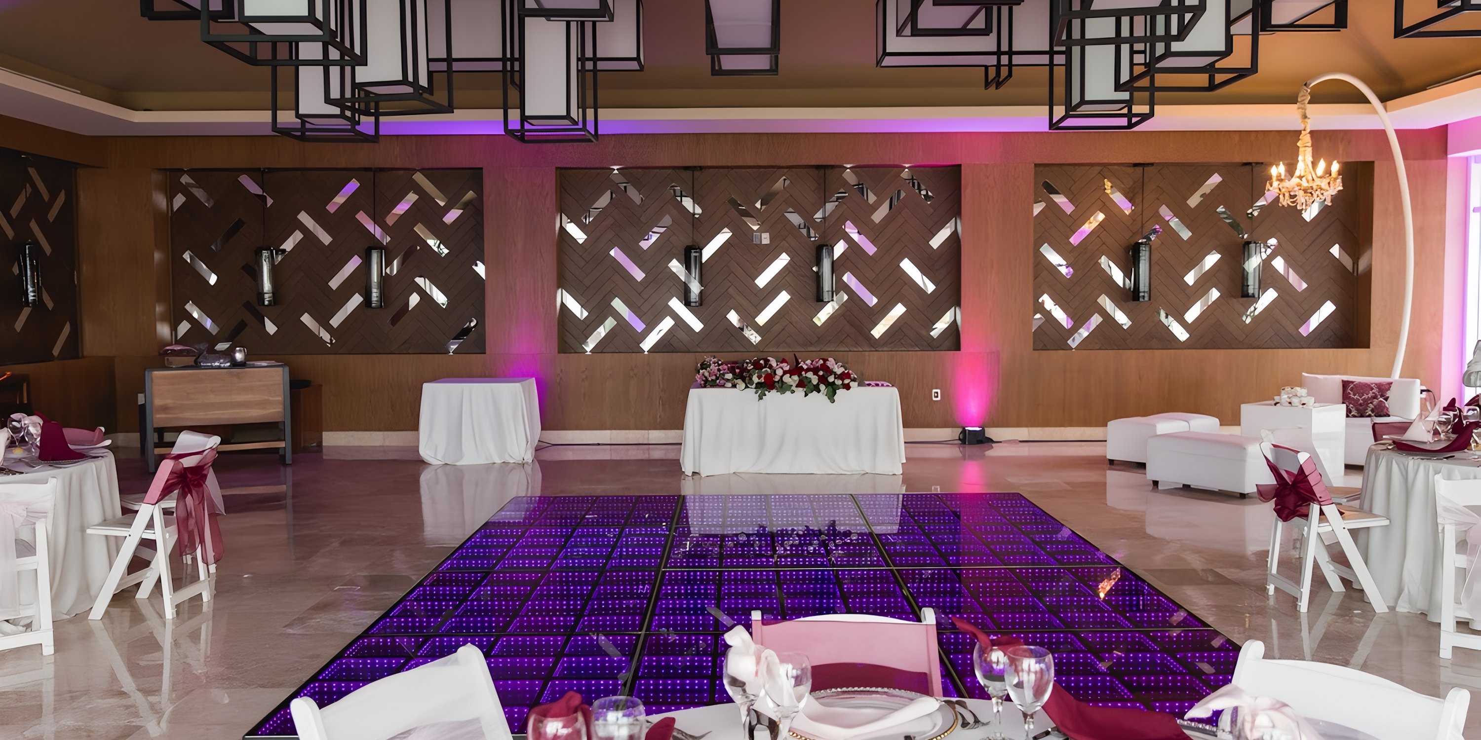 Dreams Jade Riviera Cancun: wedding event hall with geometric panels, purple dance floor, banquet tables.