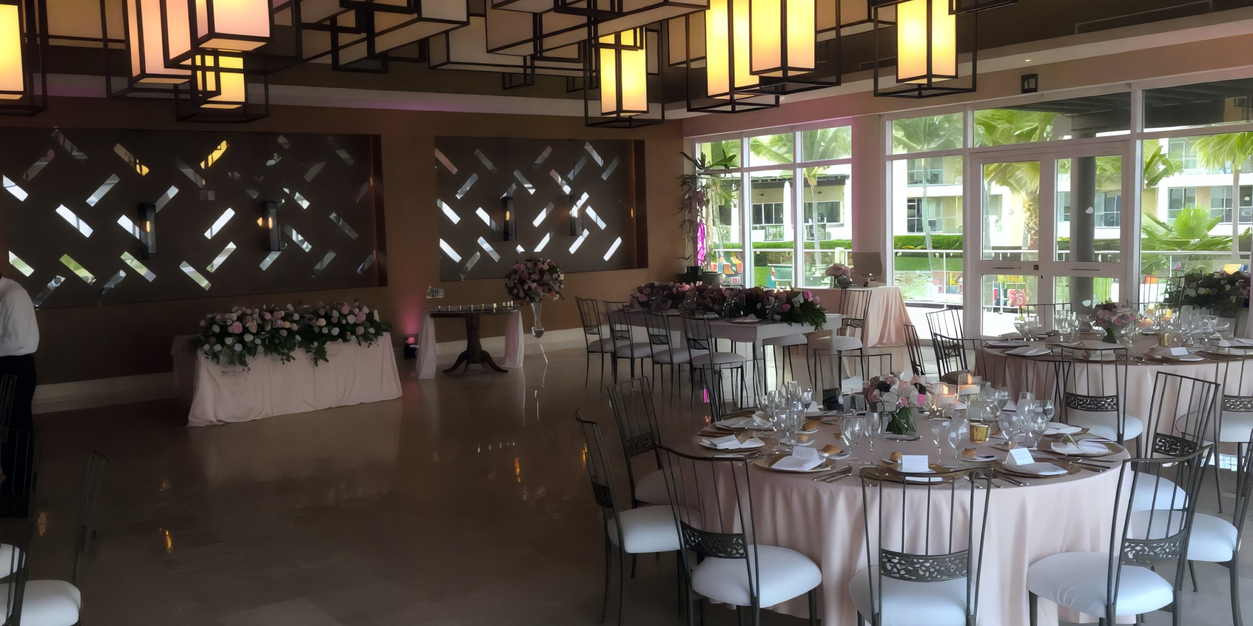 Dreams Jade Riviera Cancun hosts a stunning destination wedding reception adorned with floral decor and framed by large windows.