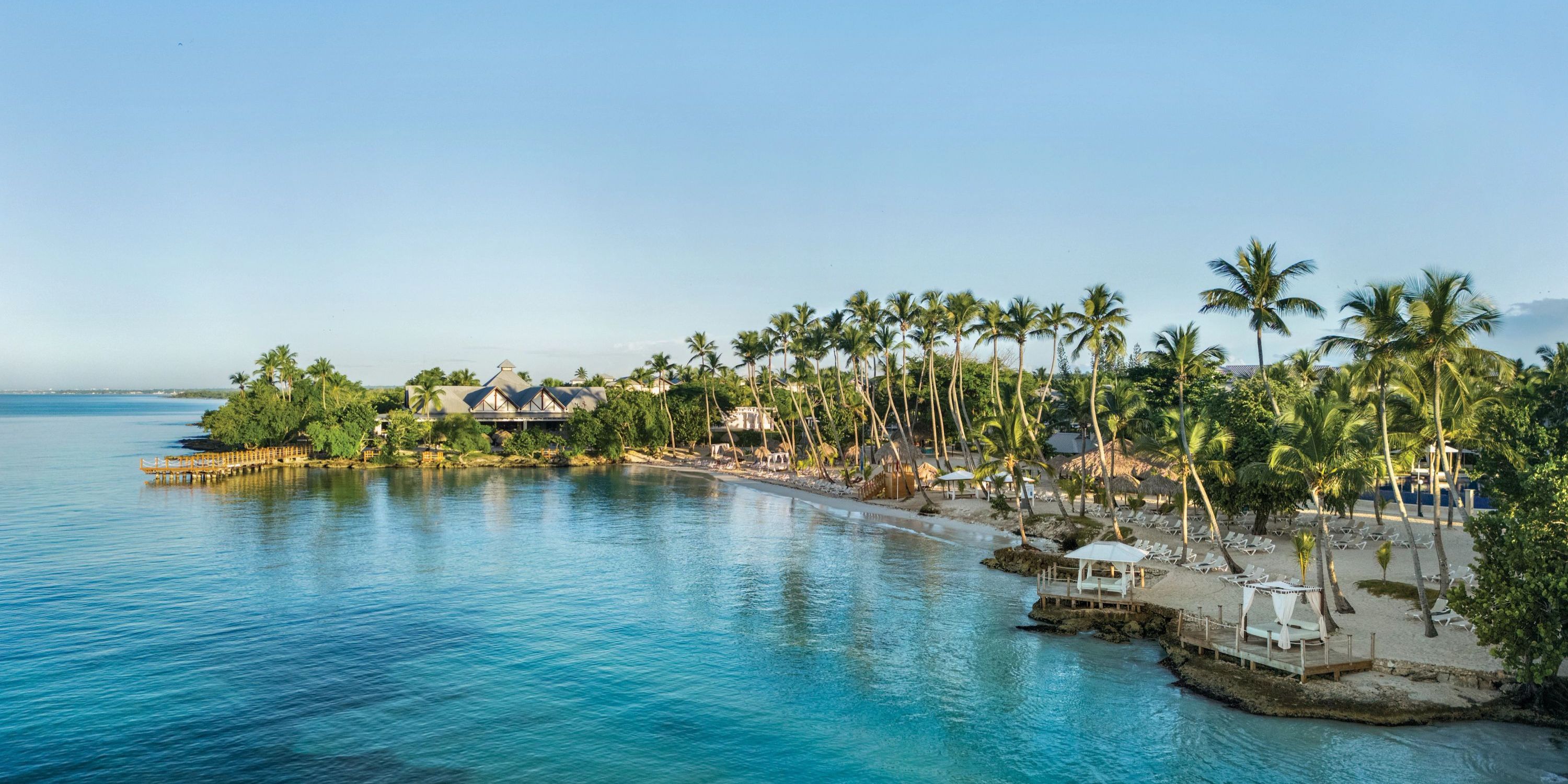 Hilton La Romana: a stunning tropical beachfront resort, featuring palm trees, clear blue waters, and white sand—perfect for a romantic destination wedding.