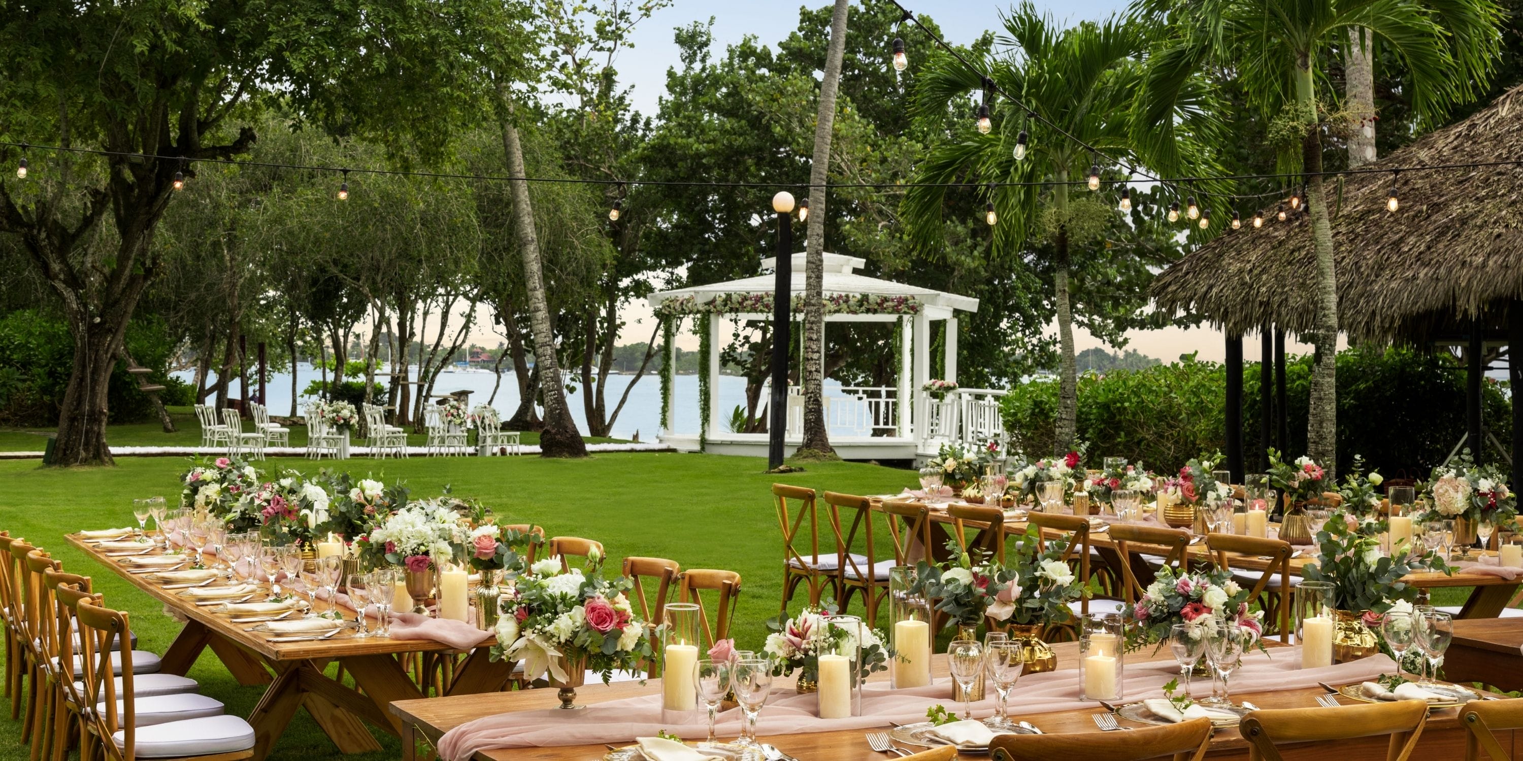 Destination wedding at Dreams La Romana with wooden tables, floral accents, and a white gazebo.
