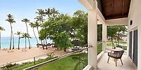 Hilton La Romana balcony featuring a table and chairs, offering stunning views of the sandy beach, swaying palms, and turquoise ocean—a perfect setting for a romantic destination wedding.