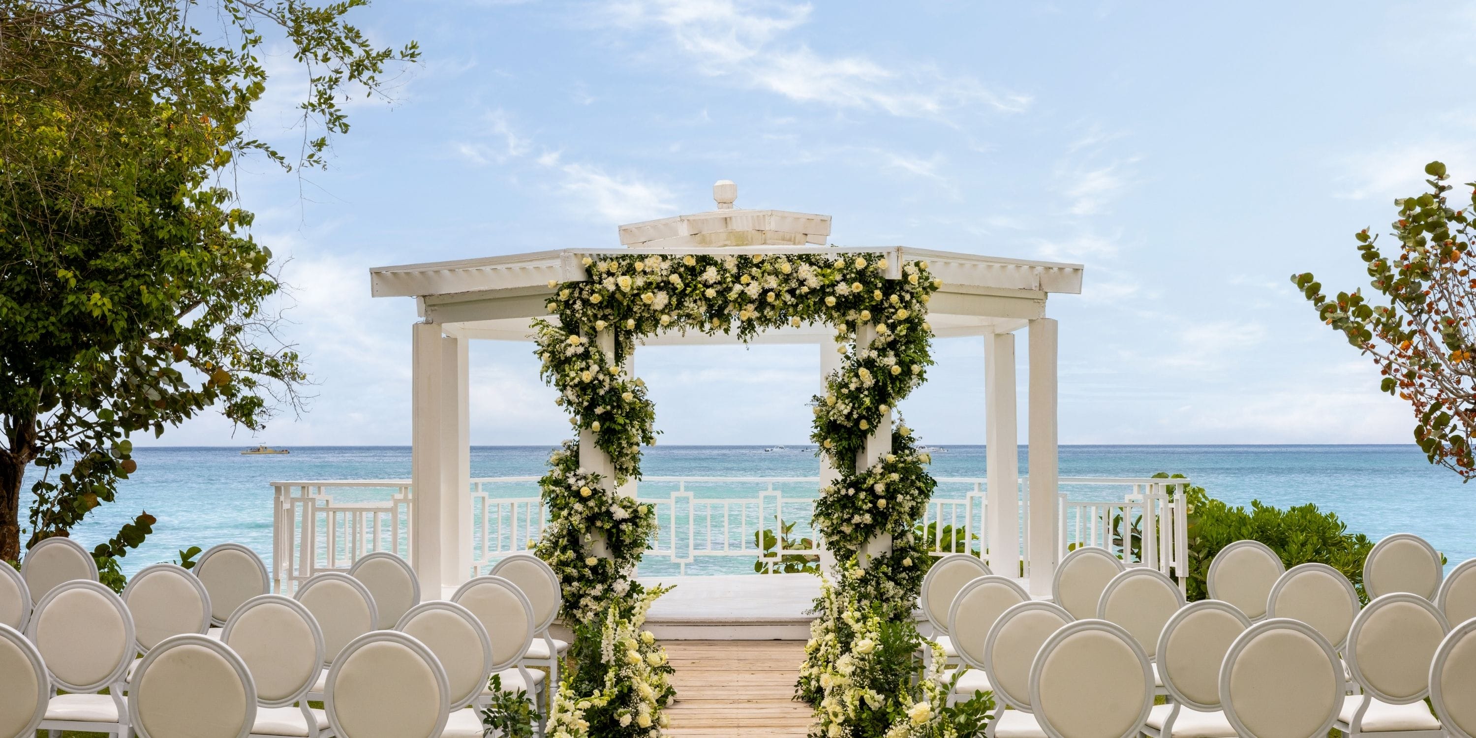 Dreams La Romana Resort: oceanfront white gazebo and chairs arranged for a destination wedding.
