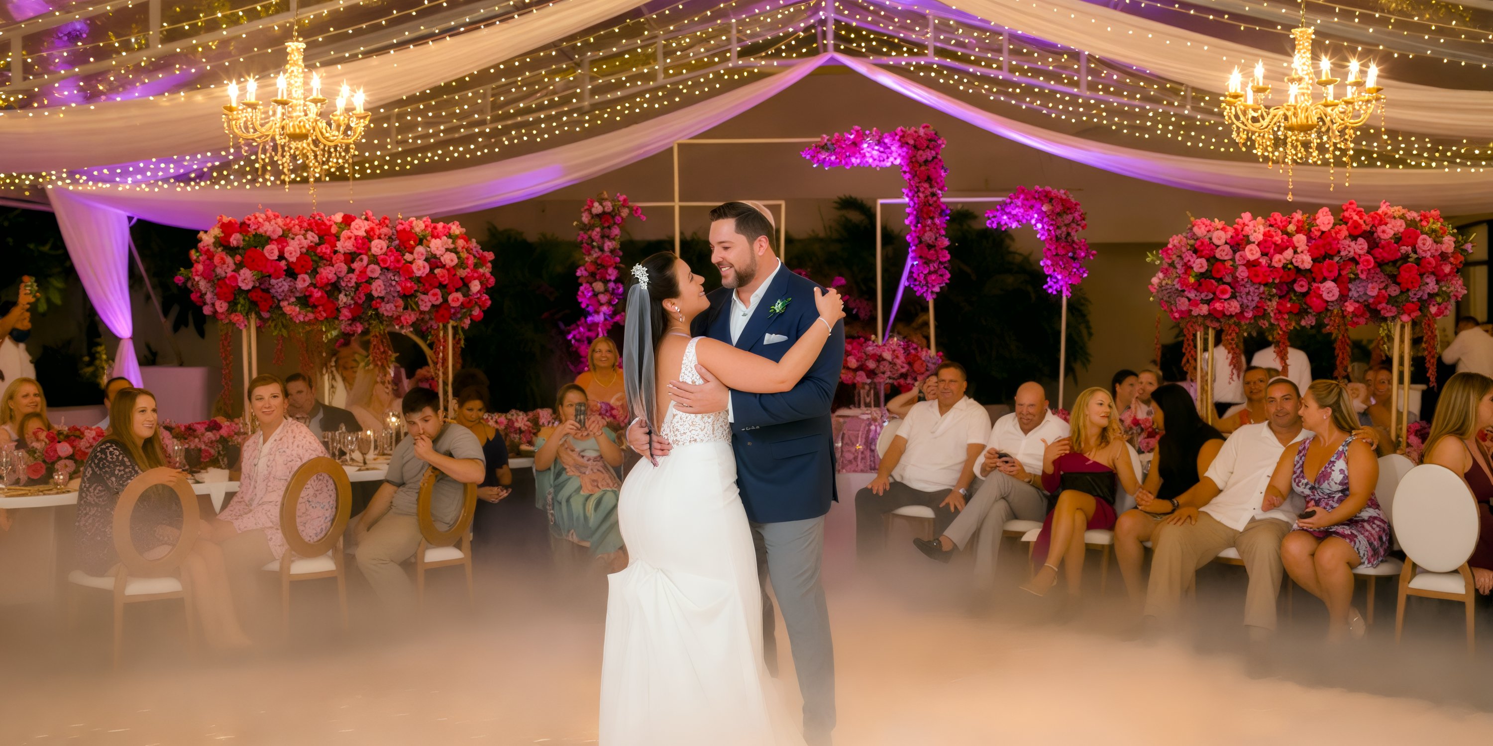 The bride and groom share their first dance at their destination wedding at Dreams Natura, surrounded by guests who look on with joy.
