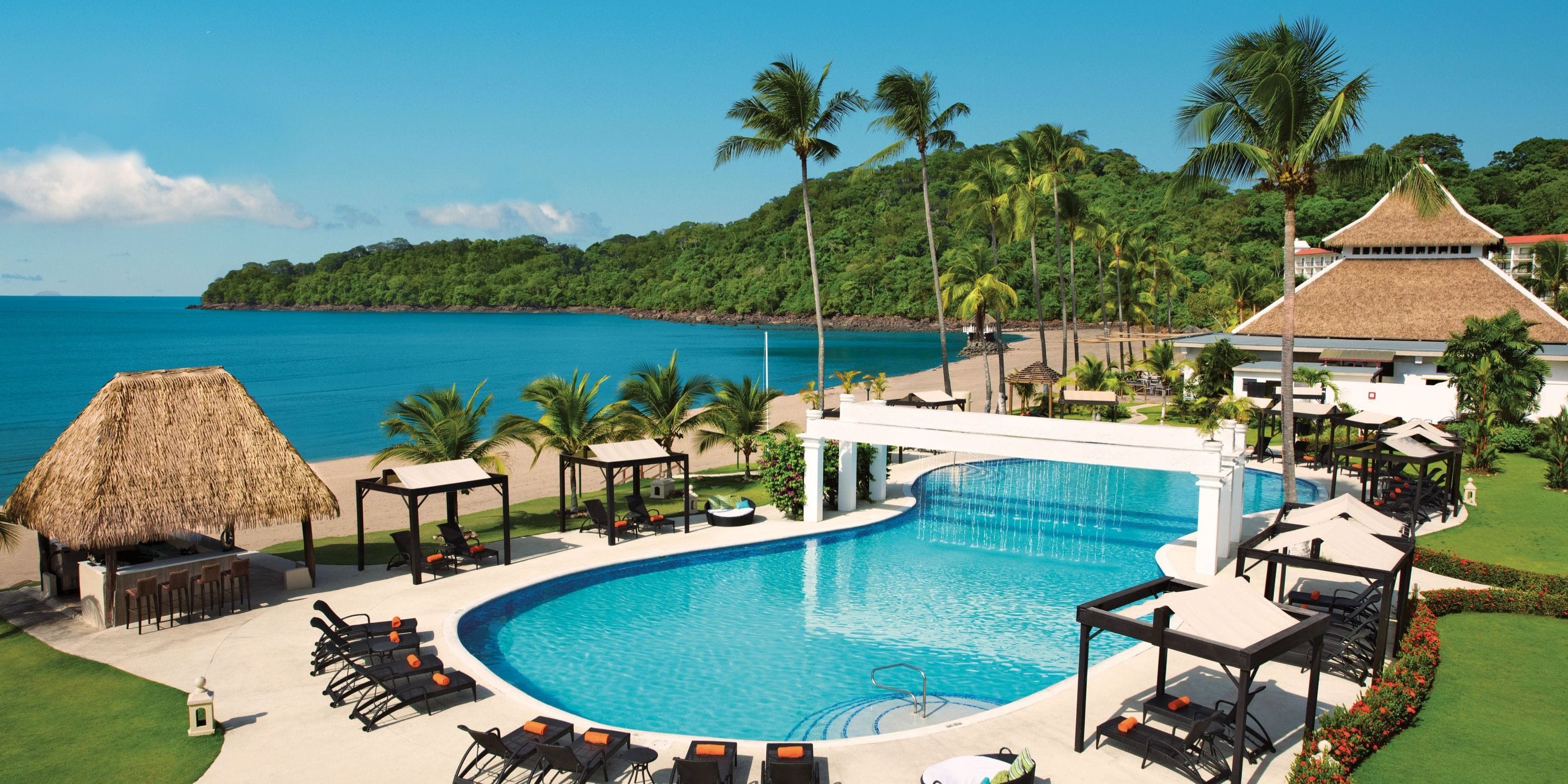 Dreams Playa Bonita: idyllic destination wedding spot with resort pool, lounge chairs, cabanas, and palms.