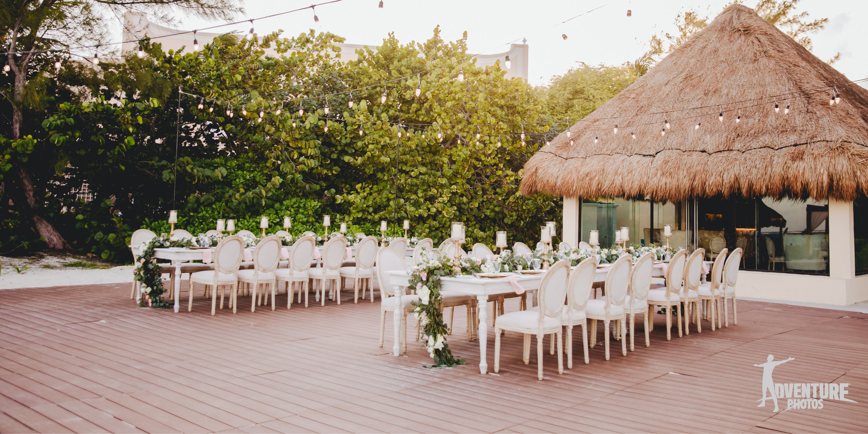 Dreams Sapphire destination wedding setup with white chairs, decorated tables, and romantic string lights.