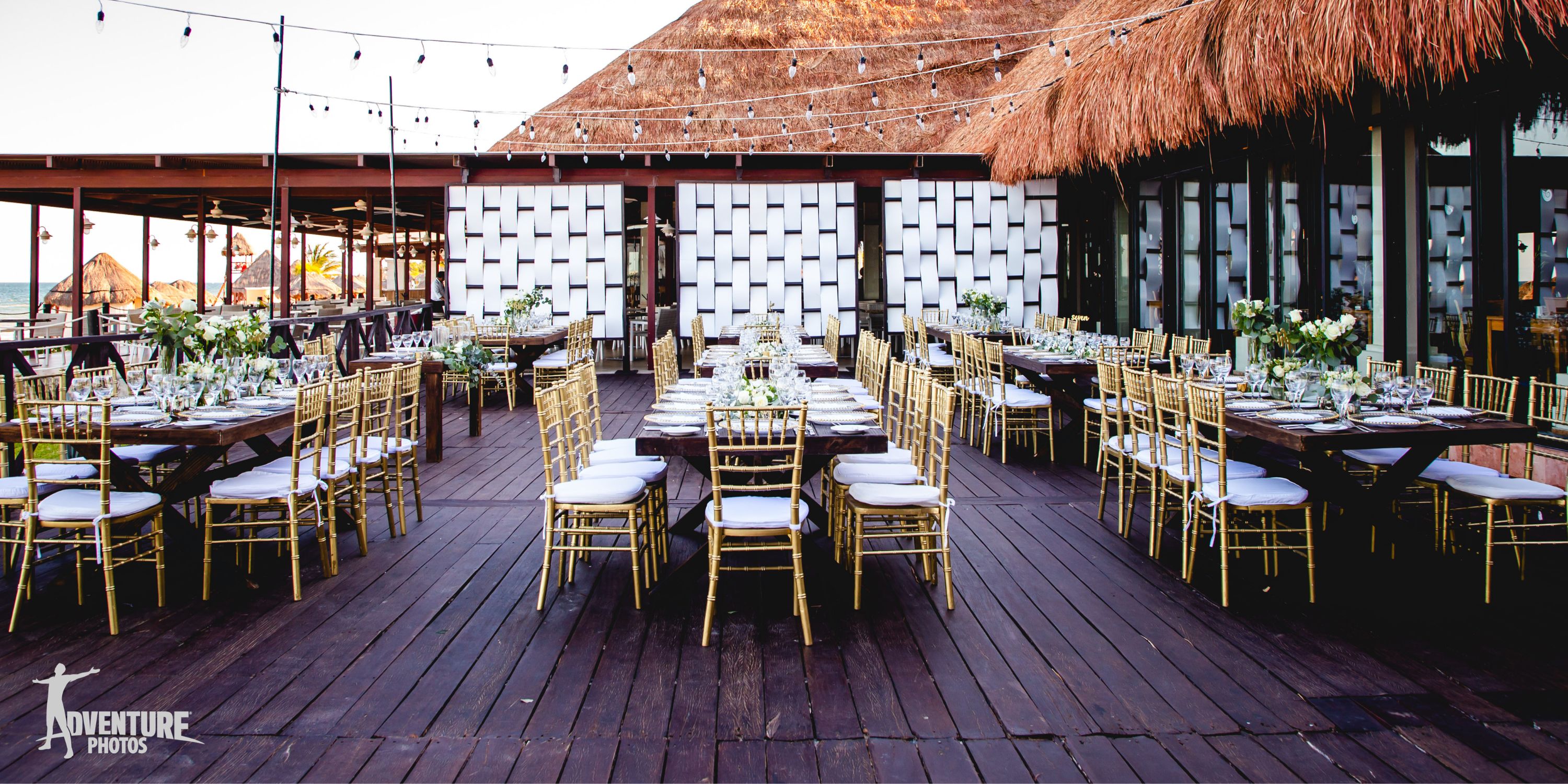 Elegant destination wedding at Dreams Sapphire with gold chairs, wooden tables, and glowing string lights.