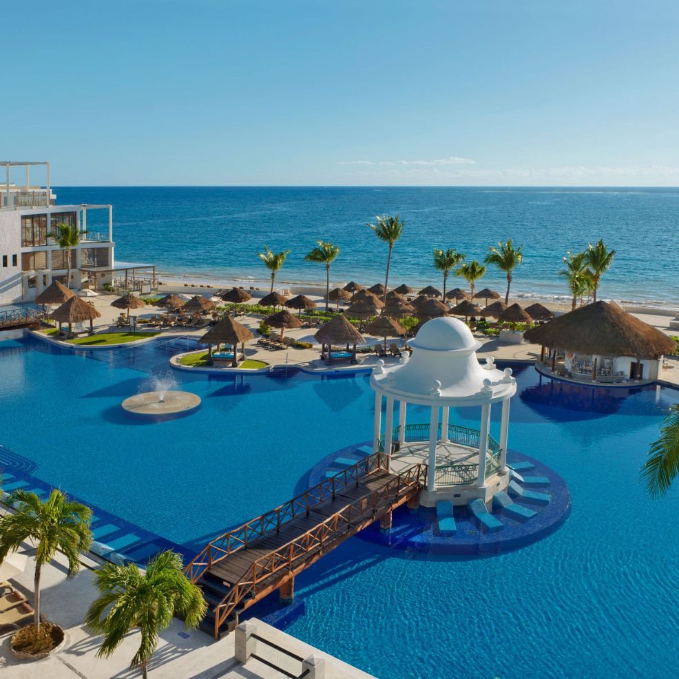 Large pool with a white gazebo perfect for a destination wedding, plus palm trees and ocean views.