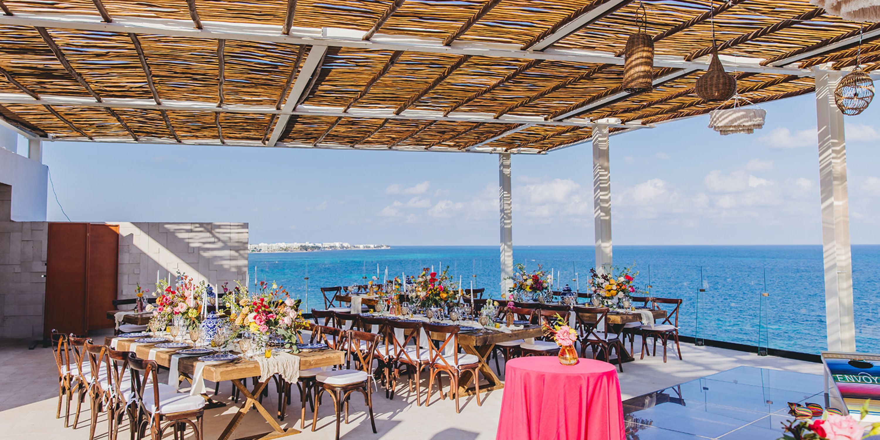 Dreams Sapphire: Outdoor dining space with ocean views under a bamboo roof, perfect for a destination wedding.