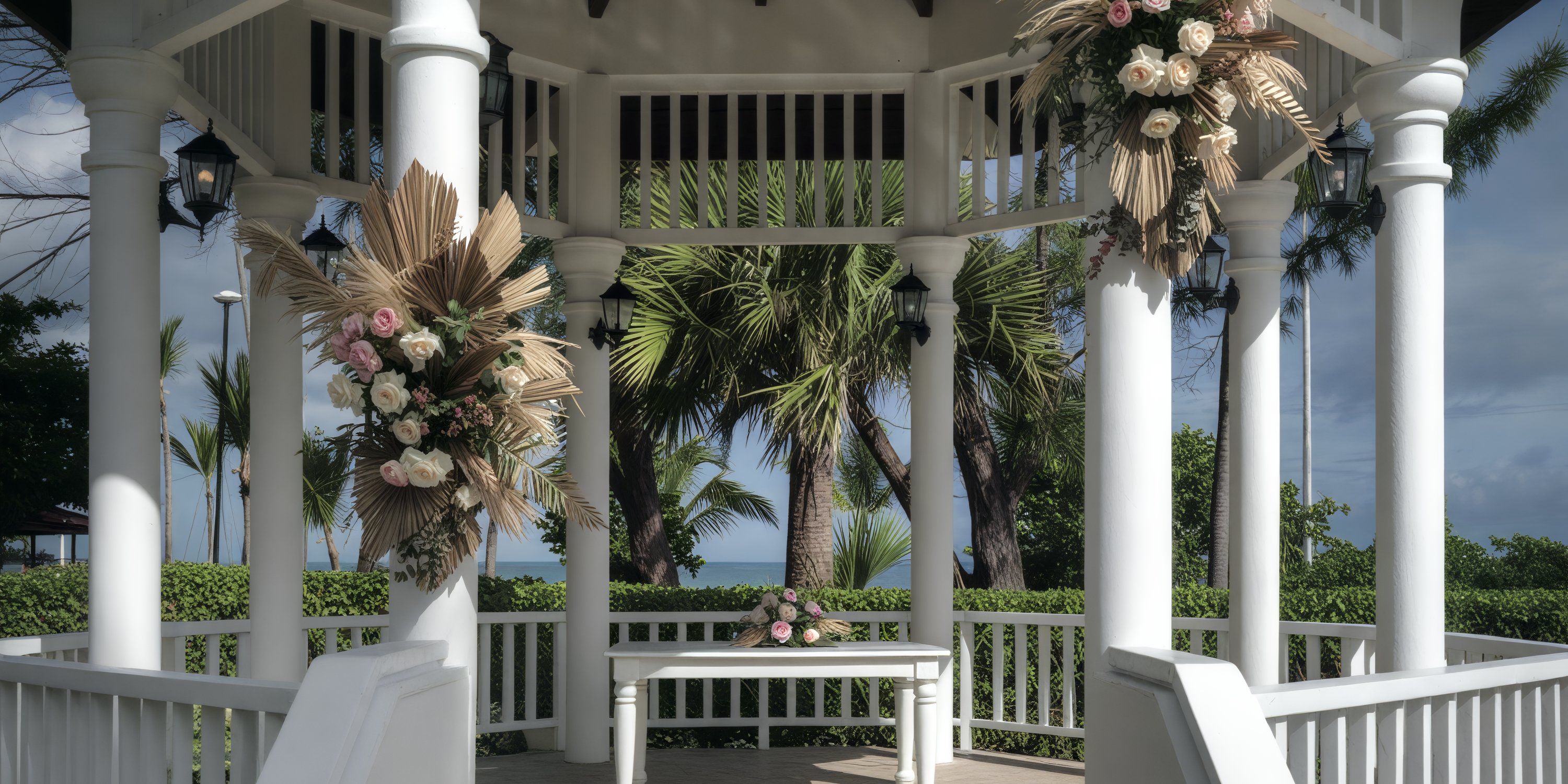 Grand Palladium Palace wedding gazebo adorned with flowers, overlooking palm trees and the ocean.