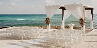 Destination wedding at Generations Riviera Maya: white chairs, floral accents, and a seaside canopy.