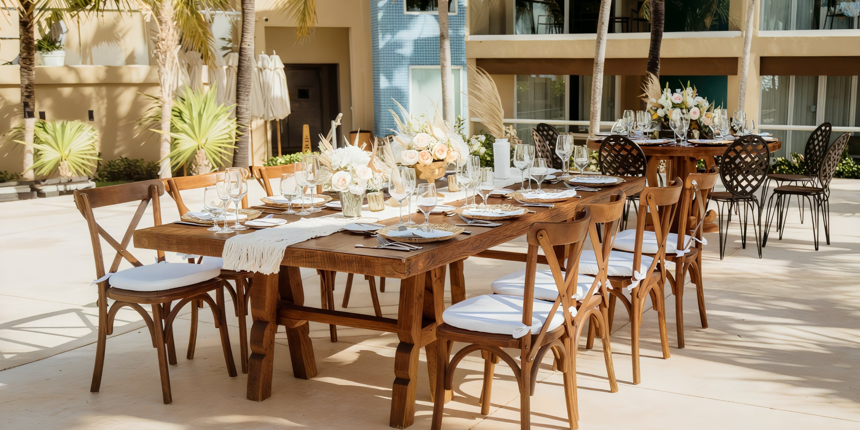 Outdoor tables at Hard Rock Cancun set with plates, glasses, and flowers for a destination wedding.