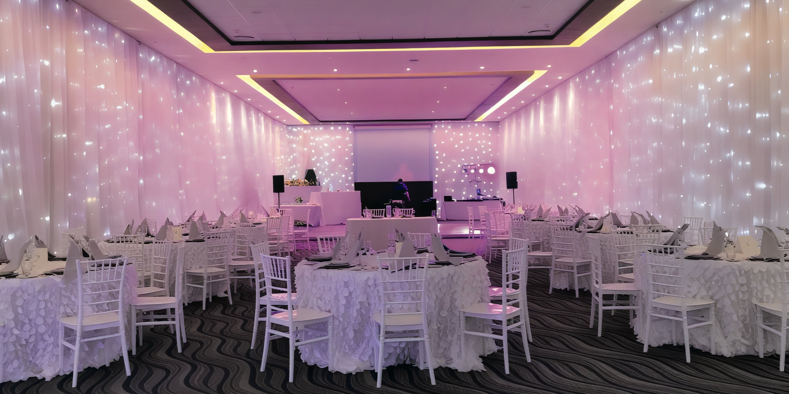 Hideaway at Royalton Riviera Cancun: Elegant white event hall with round tables, perfect for a destination wedding.