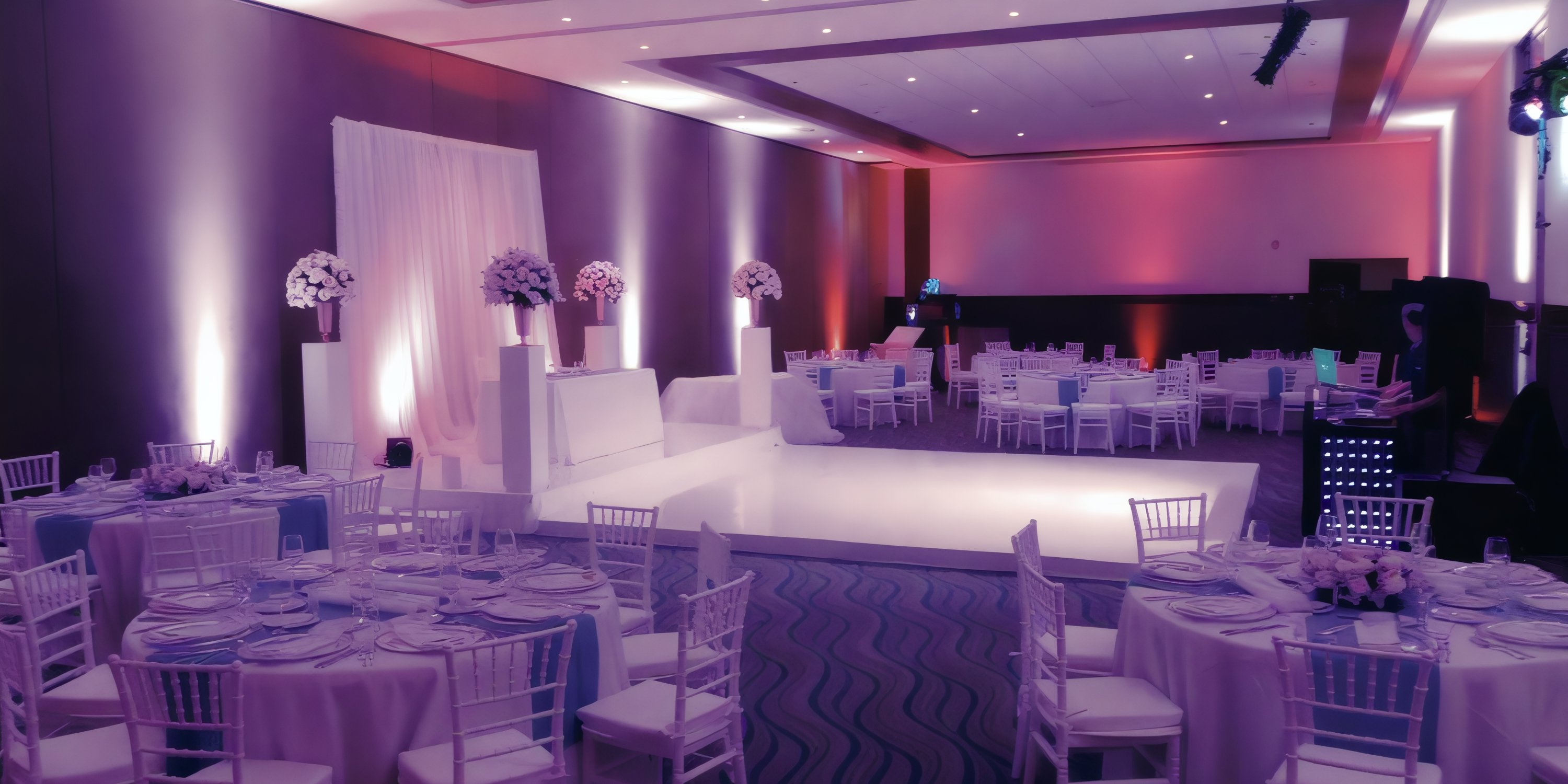 Destination wedding setup at Hideaway Royalton Riviera Cancun with round tables, white chairs, and purple lights.