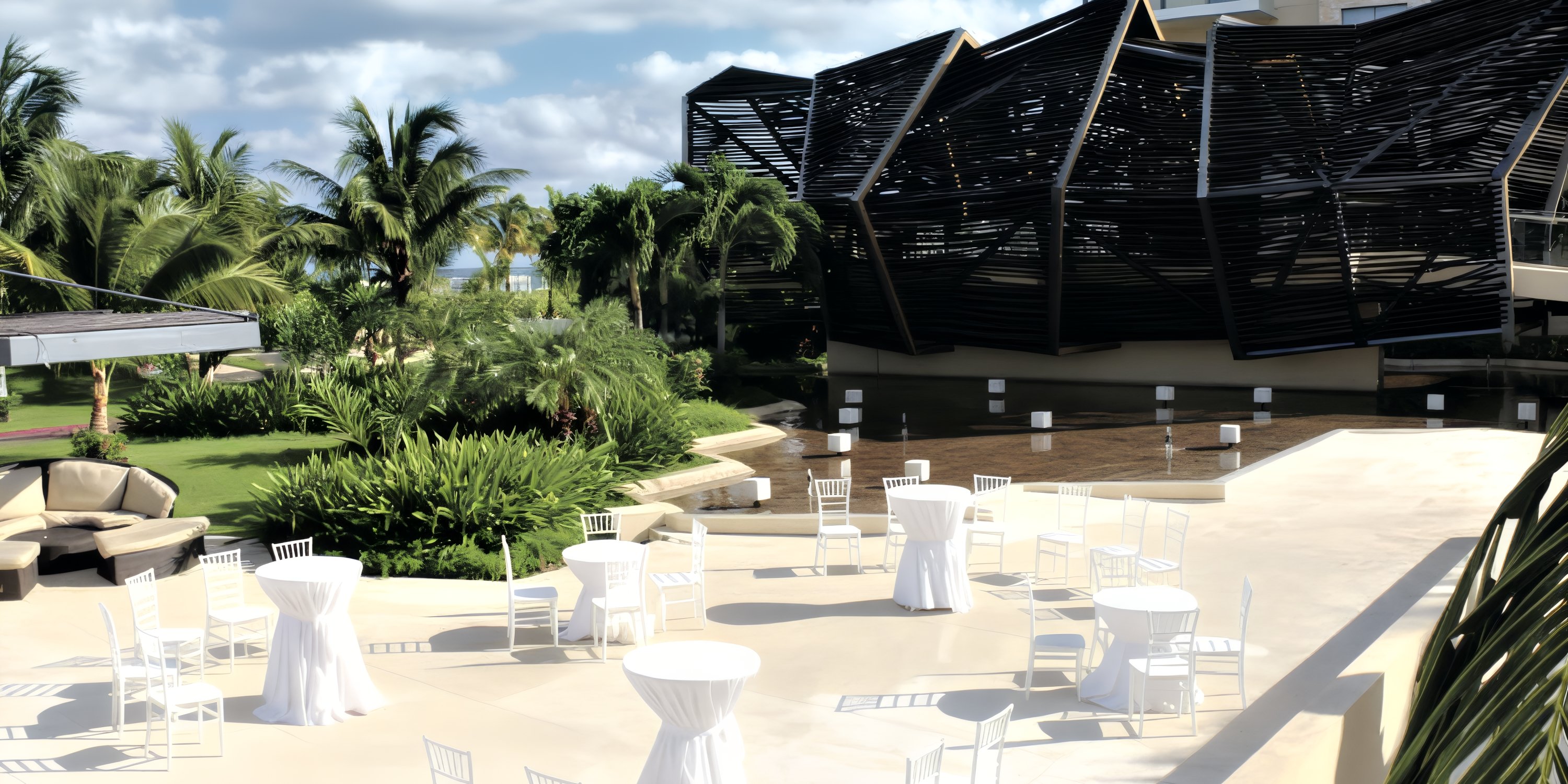 Hideaway at Royalton Riviera Cancun: Outdoor patio set for a destination wedding, round tables, lush view.