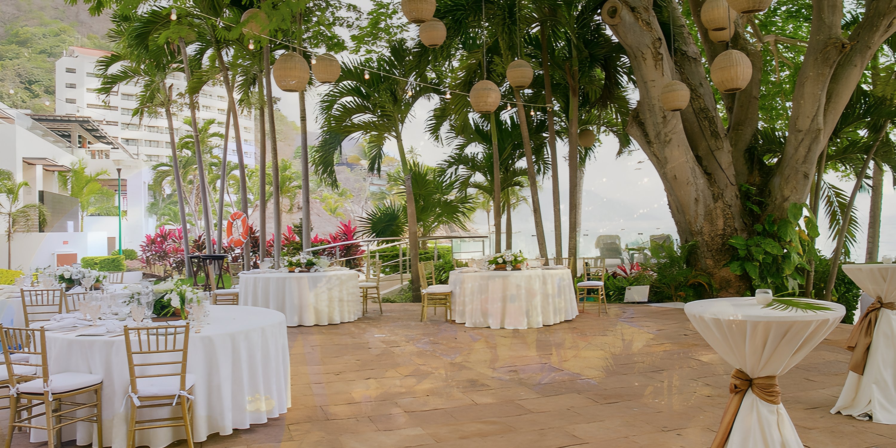 Destination wedding reception setup at Hyatt Ziva Puerto Vallarta with round tables and string lights.