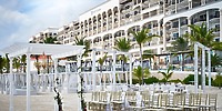 White chairs and wedding decorations arranged on the beach for a destination wedding at Hyatt Zilara Cancun.