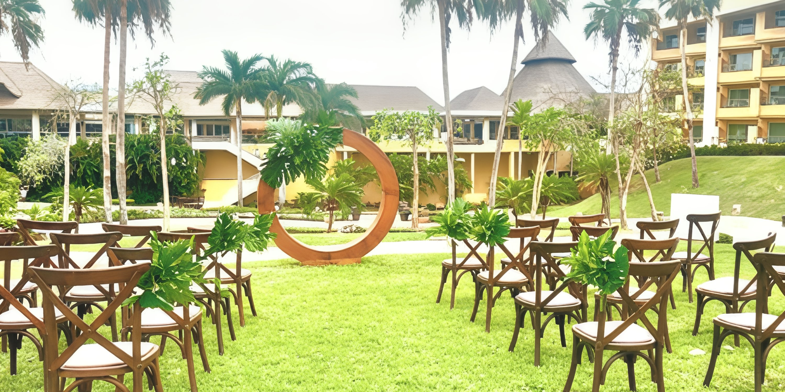 Destination wedding at Iberostar Selection Playa Mita featuring wooden chairs and a circular floral arch.