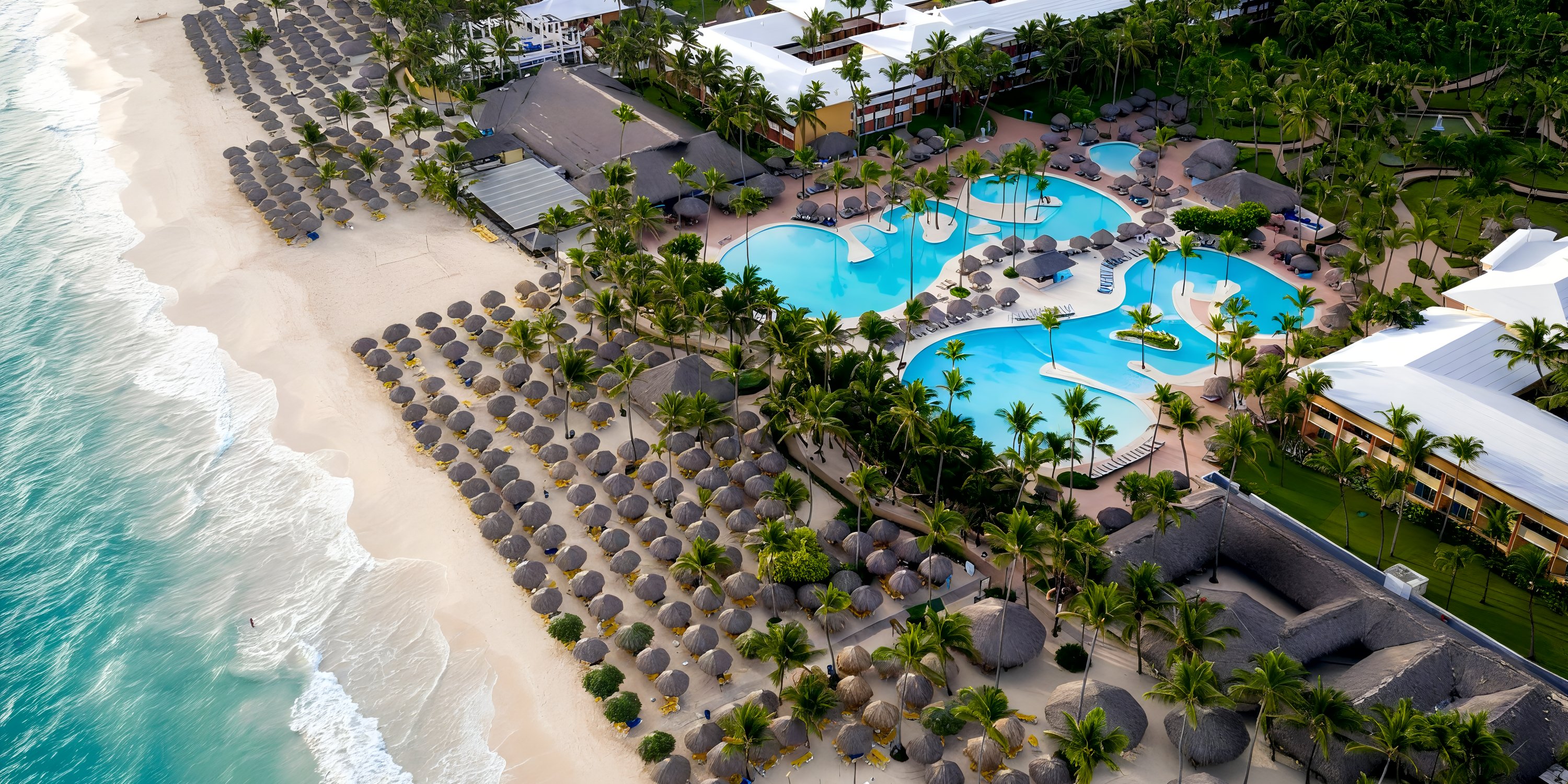 Aerial view of Iberostar Waves Punta Cana, a stunning destination wedding spot with pools and palms.
