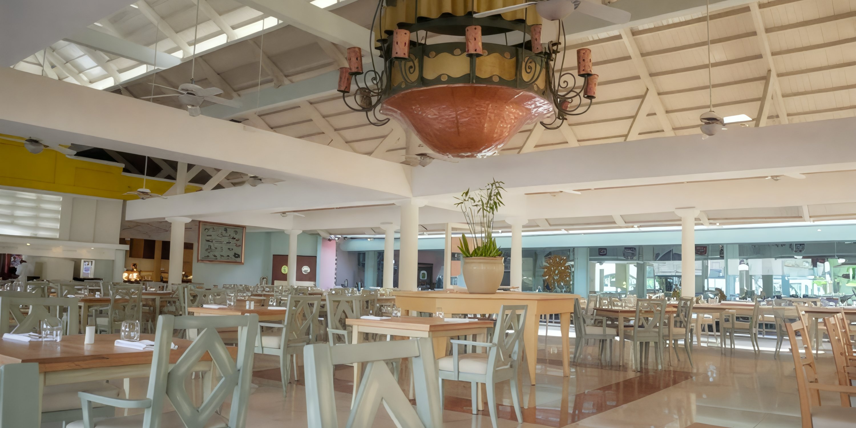 Bright, sunlit Iberostar Waves Punta Cana set for a destination wedding with wooden tables and chandelier.