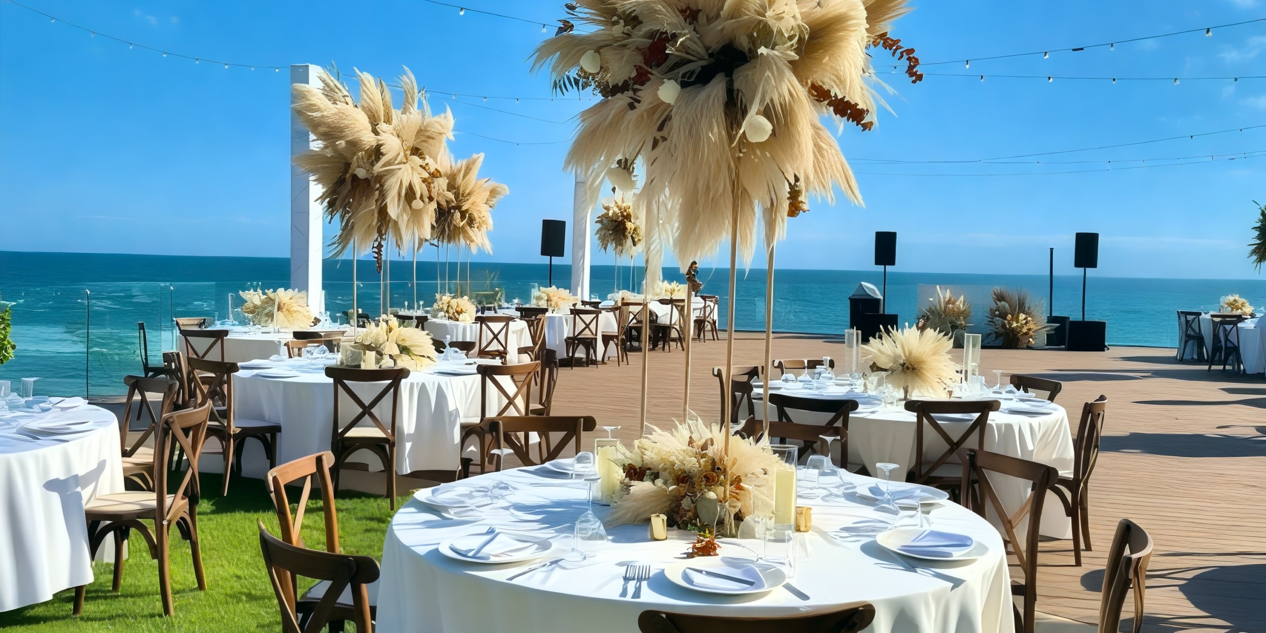 Experience the exquisite setup for a destination wedding at Dreams Bahia Mita, featuring round tables adorned with elegant white tablecloths and a breathtaking sea view.