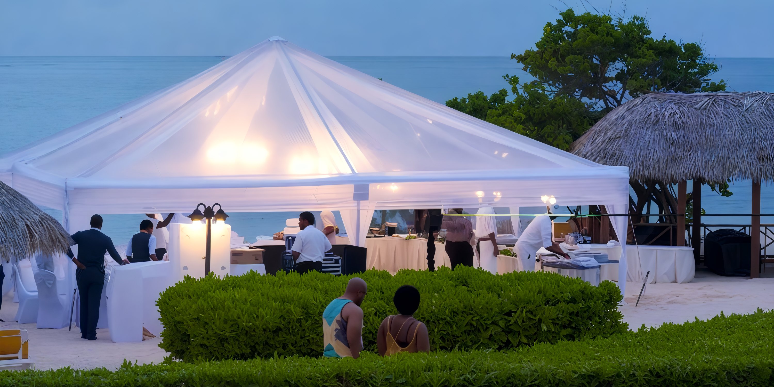 Dusk destination wedding at Iberostar Selection Rose Hall Suites, guests gathered under a white tent.