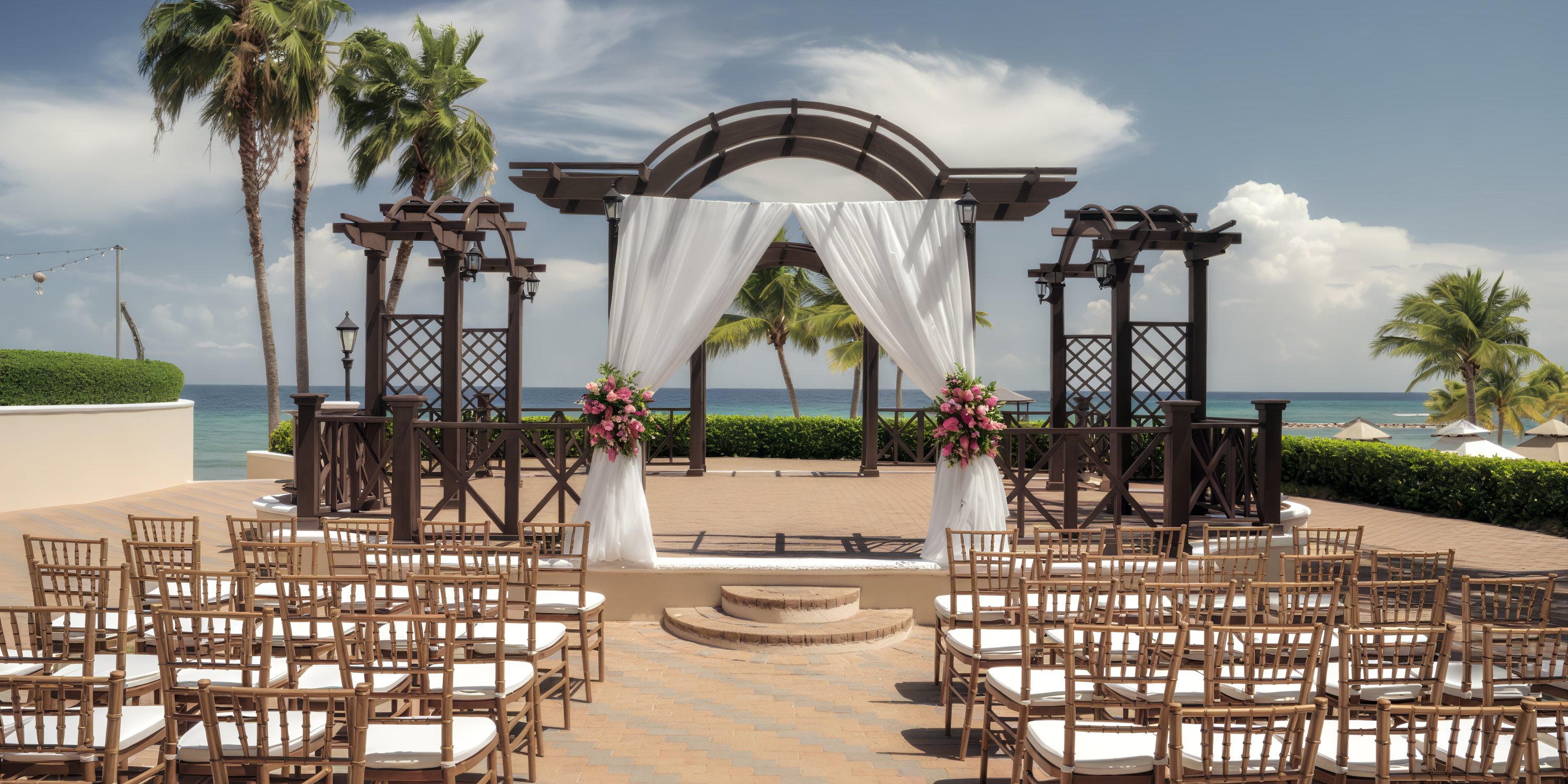 Destination wedding altar by the sea with decorated chairs and flowers at Jewel Grande Montego Bay Resort.