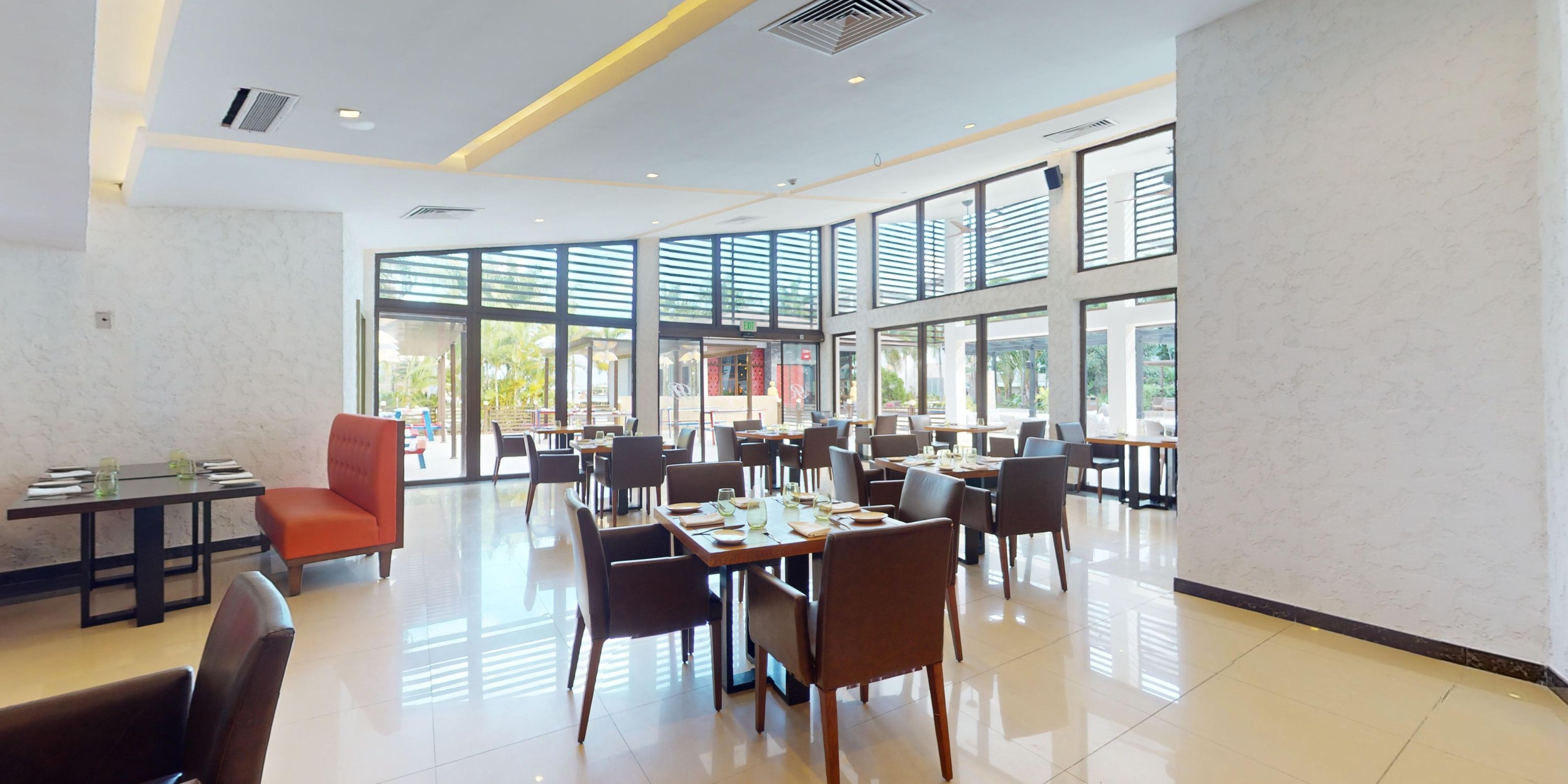 Modern, spacious wedding venue at Royalton Blue Waters featuring large windows and set tables.