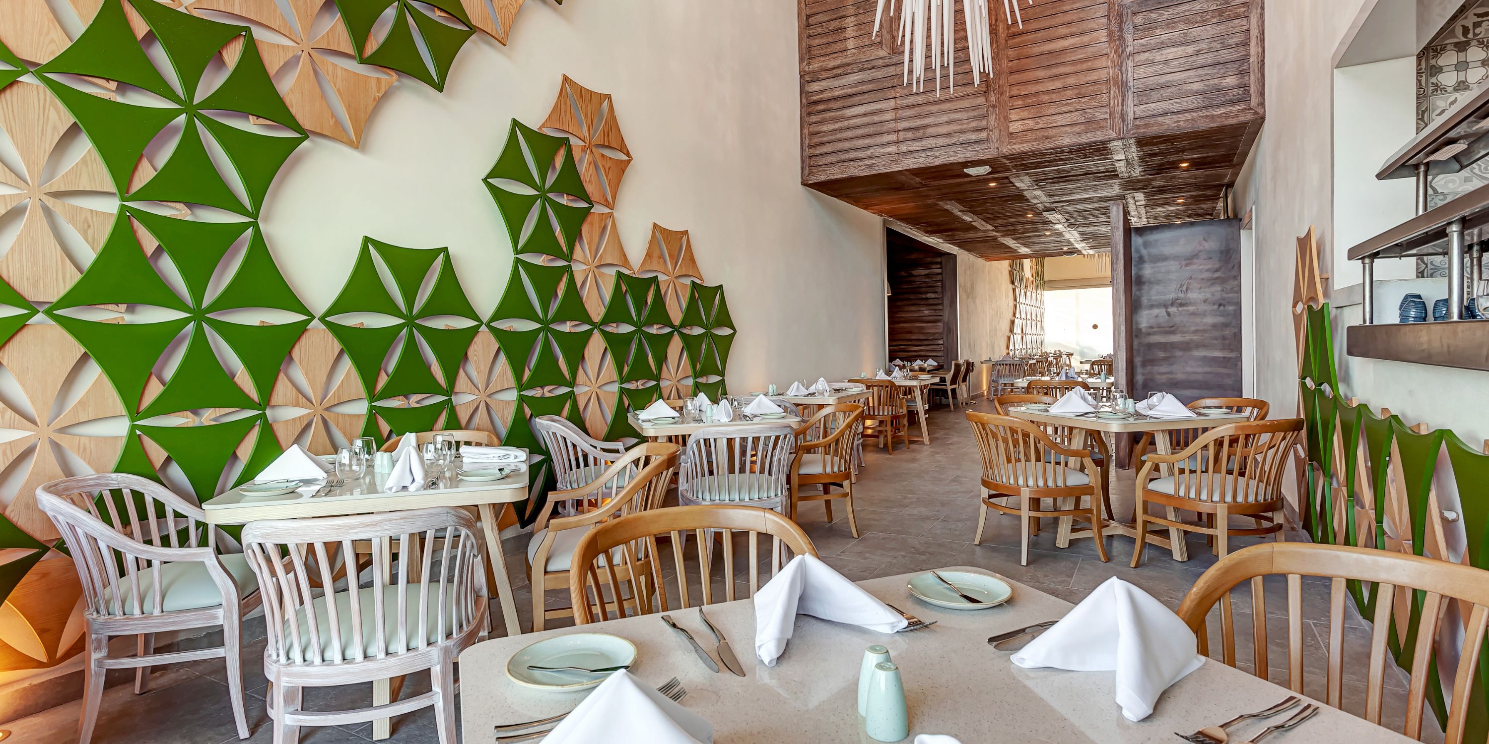 Modern interior at Royalton CHIC Suites Cancun set for a destination wedding with white napkins.