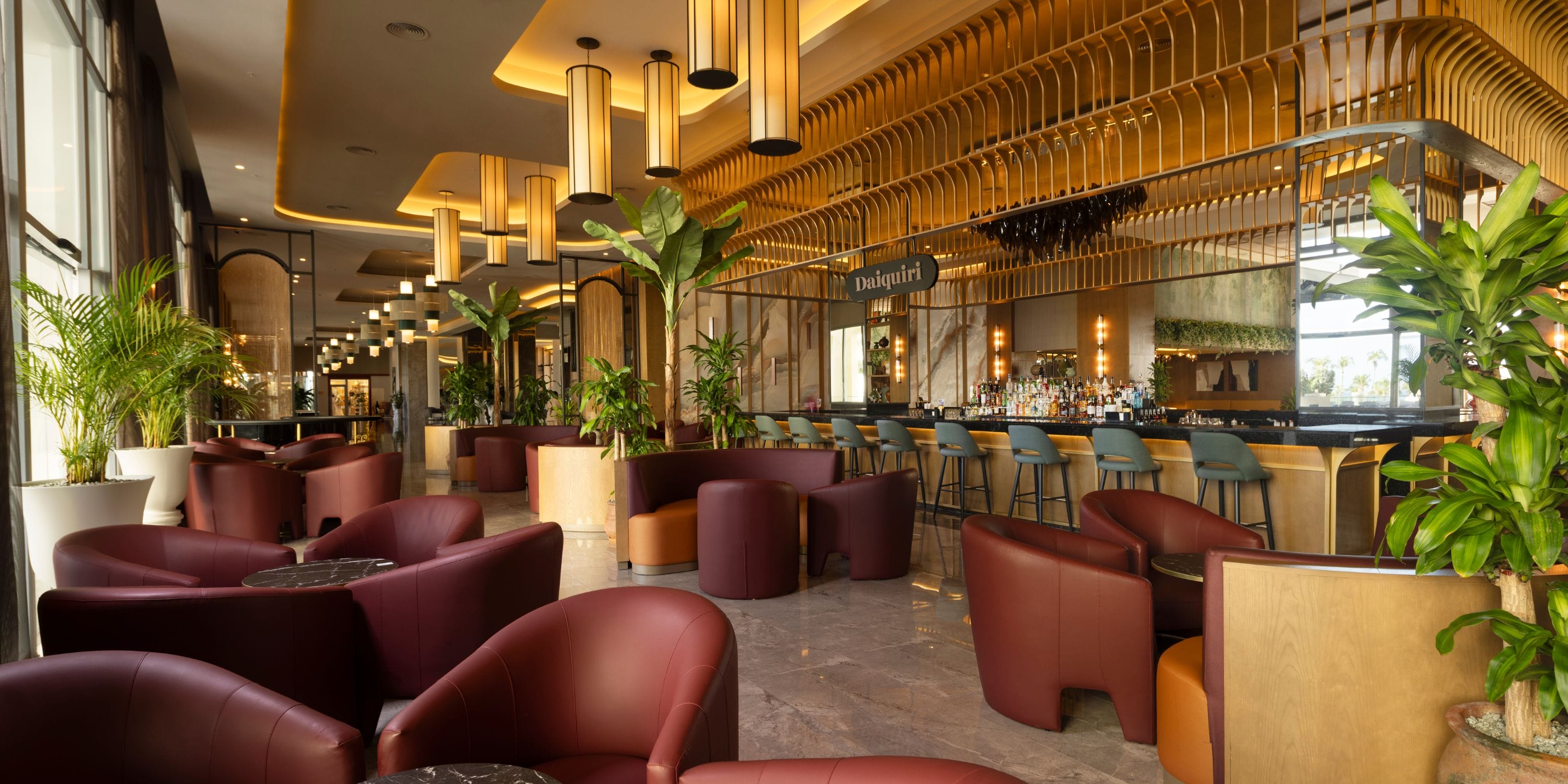 Hotel Riu Palace Aruba: chic bar lounge, brown chairs, gold accents—ideal for a destination wedding.