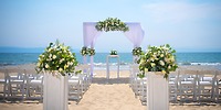 Destination wedding setup at Hotel Riu Jalisco with white chairs, florals, and an arch facing the sea.