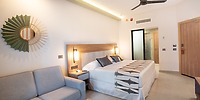 Modern Hotel Riu Jalisco room with king bed, sofa, and neutral decor—ideal for a destination wedding.