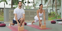 Two people practice yoga lunges with blocks outdoors at Hotel Riu Jalisco, a popular wedding venue.