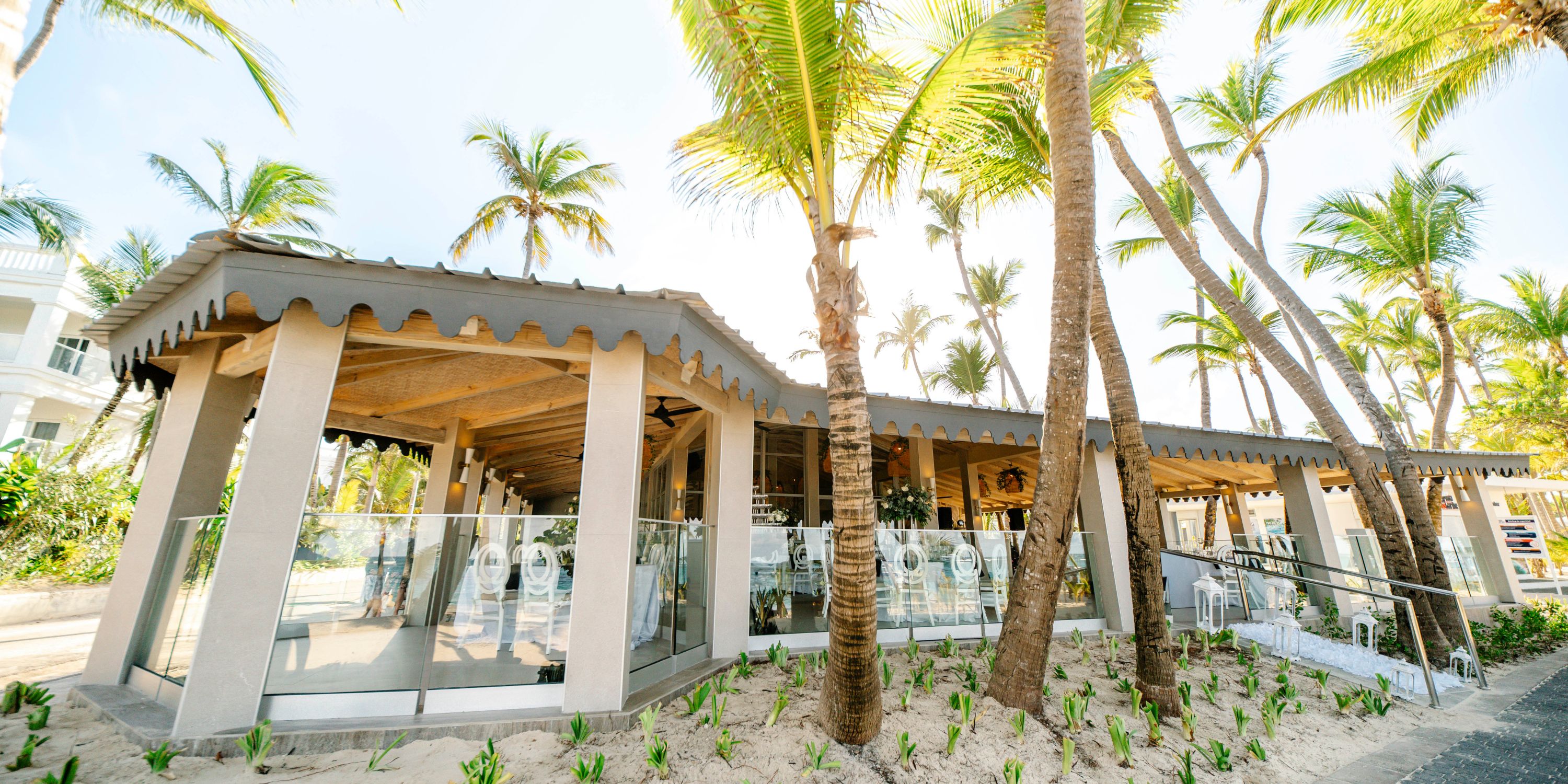 Hotel Riu Bambu: Outdoor restaurant with glass railing, palm trees&mdash;ideal for a destination wedding.