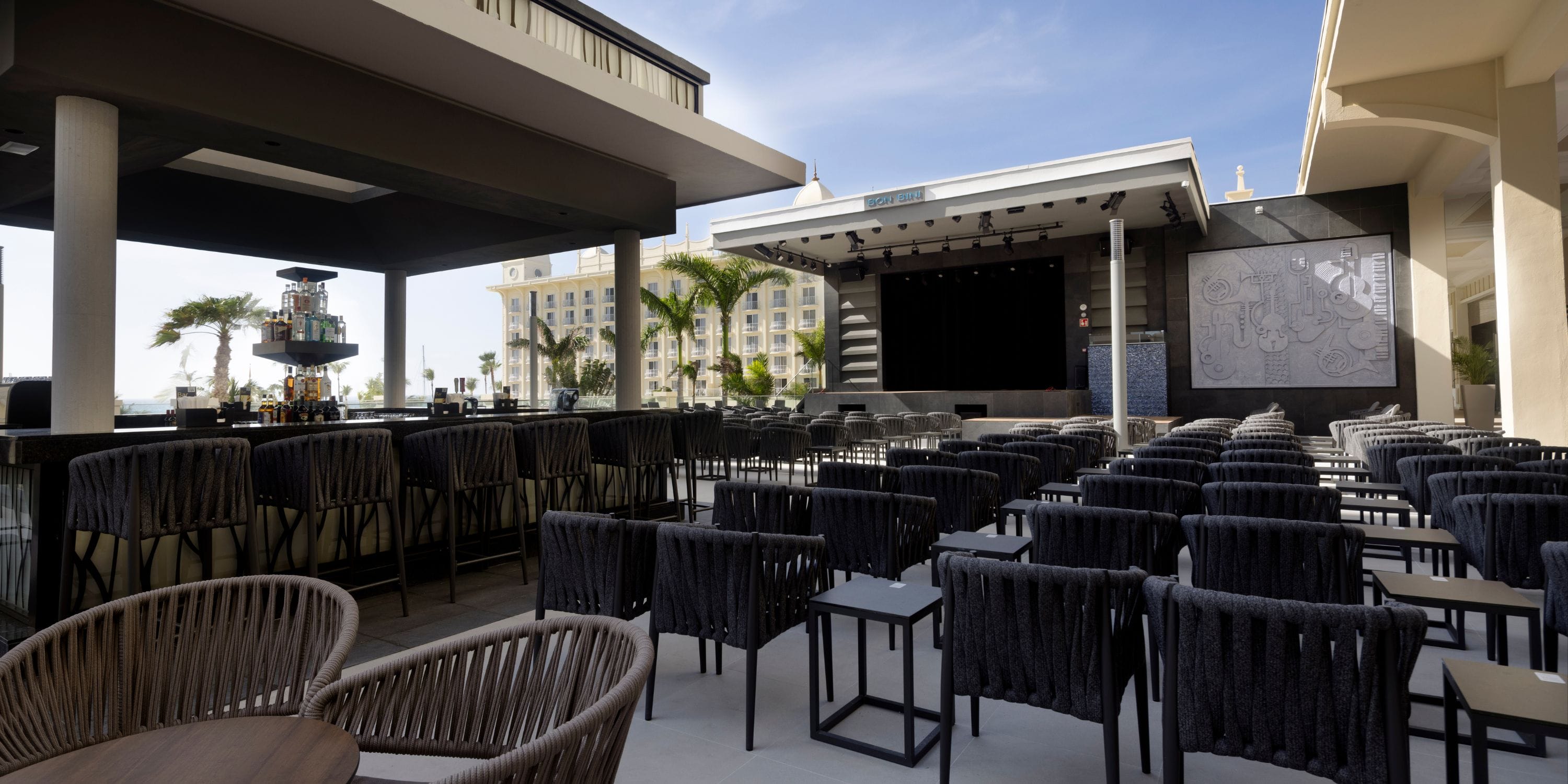 Outdoor seating at Hotel Riu Palace Aruba, perfect for a destination wedding by the stage and bar.